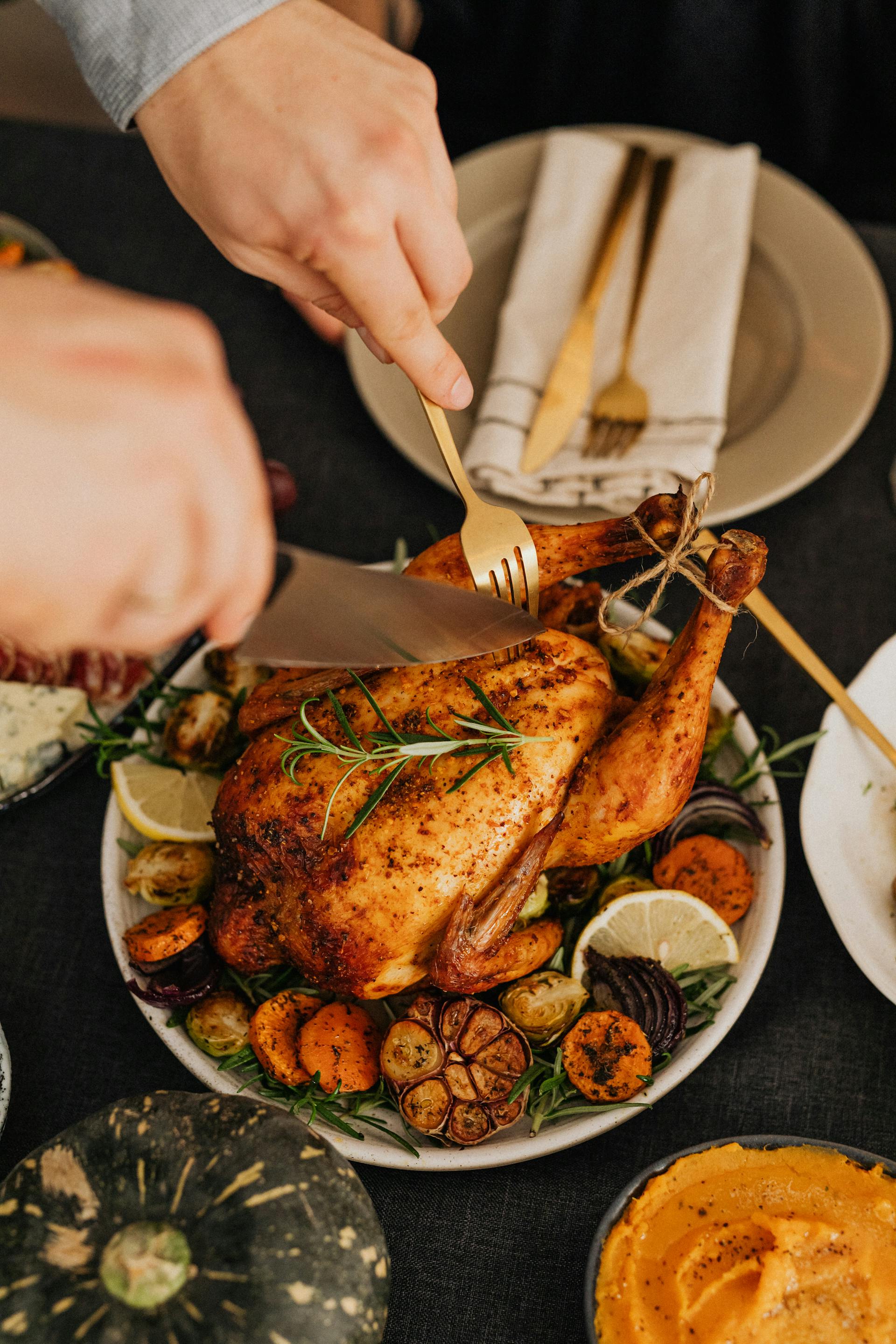 A person cutting a turkey during Thanksgiving dinner | Source: Pexels
