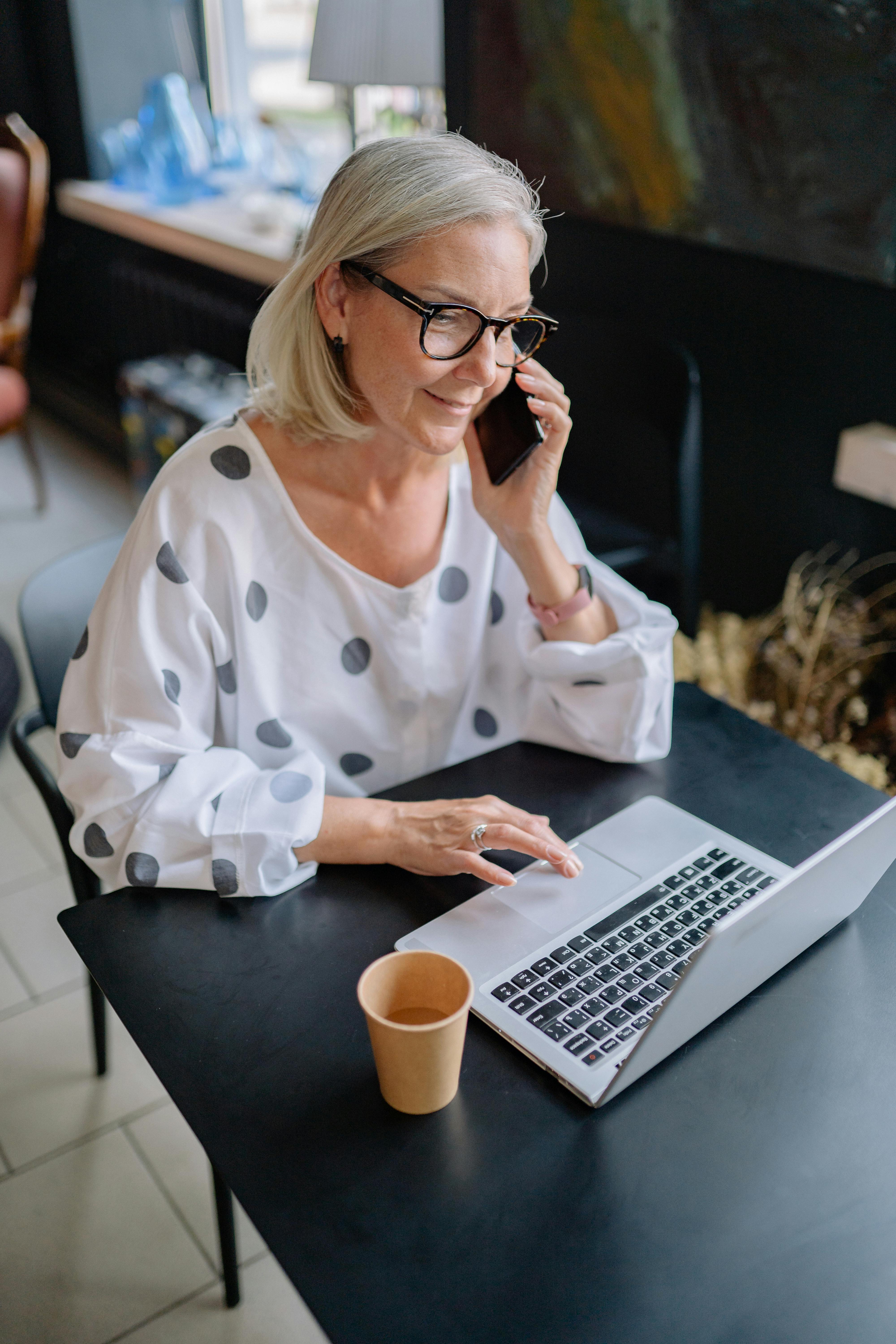 A woman using her phone and laptop simultaneously | Source: Pexels