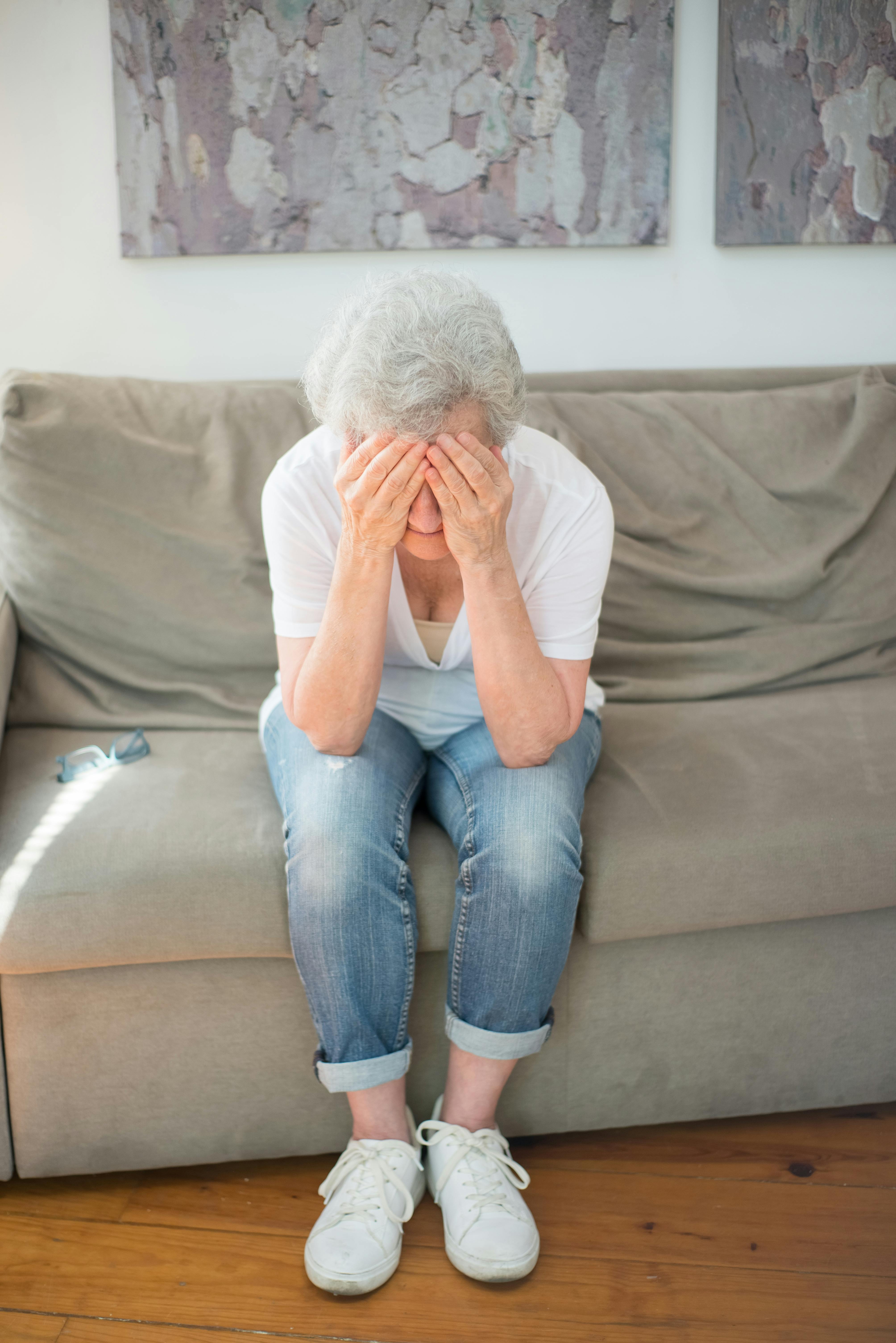 An elderly woman covering her face with her hands | Source: Pexels