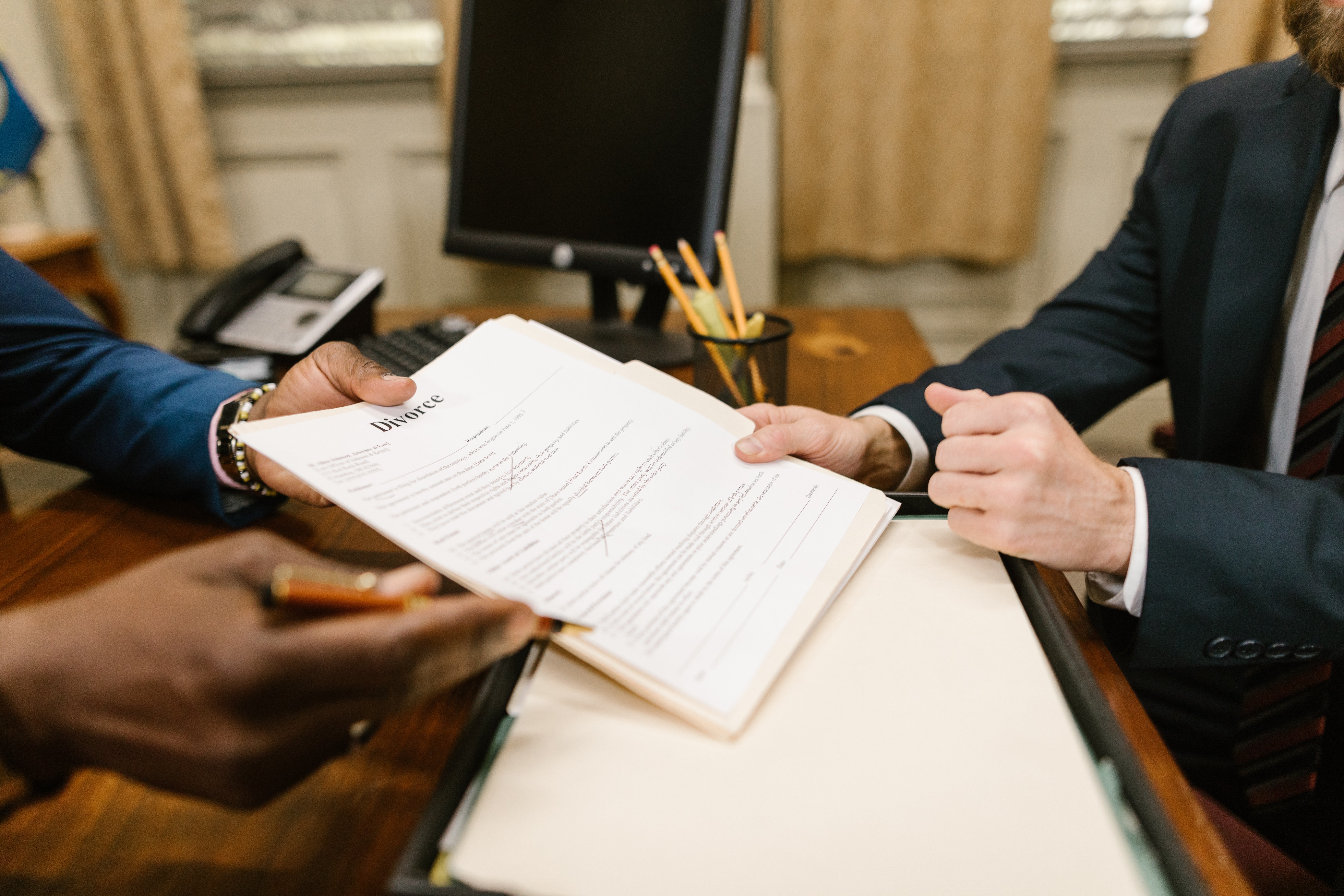 Two people holding divorce papers | Photo: Pexels