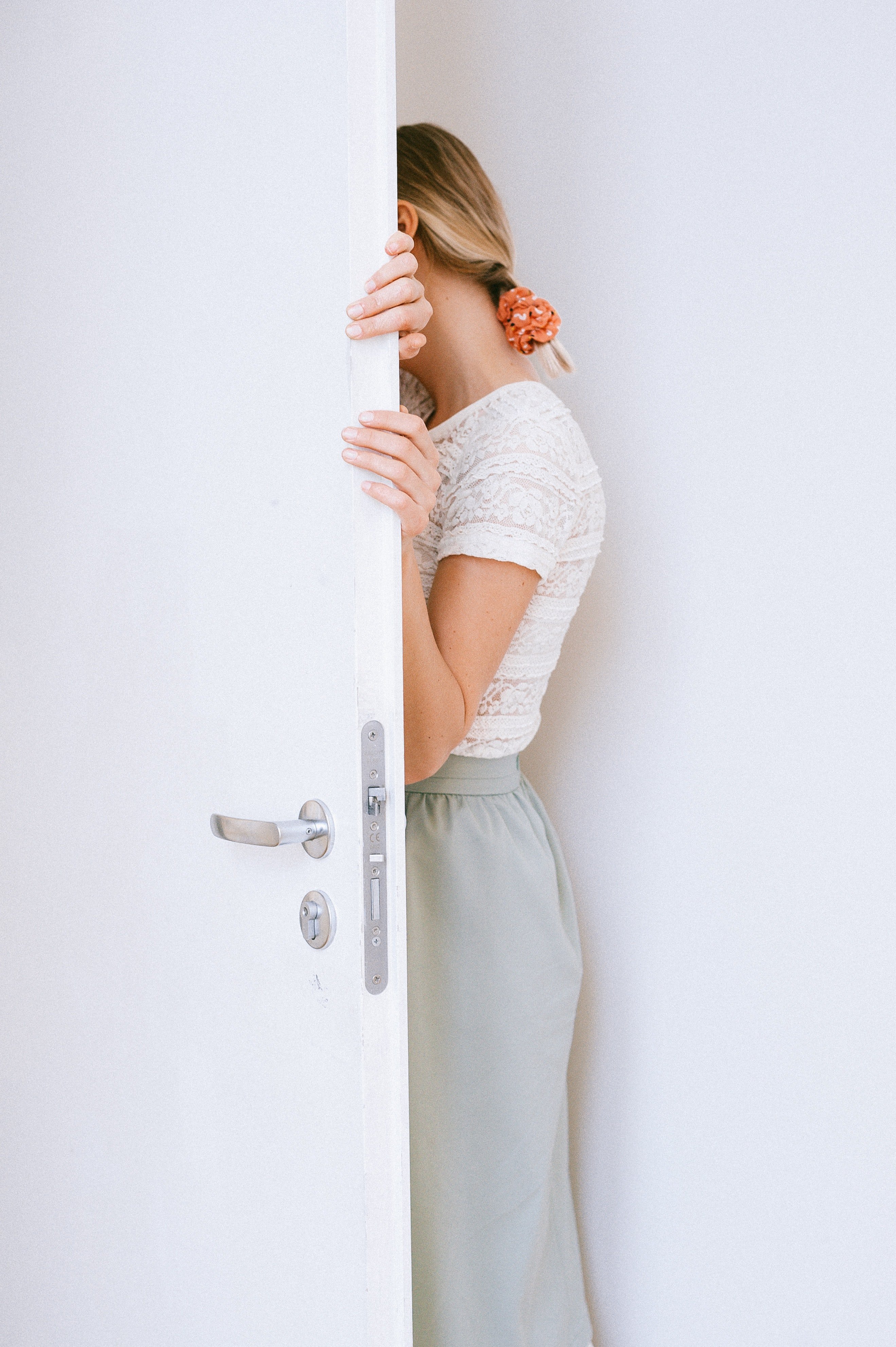 A woman leaning into an open door. | Source: Pexels. 