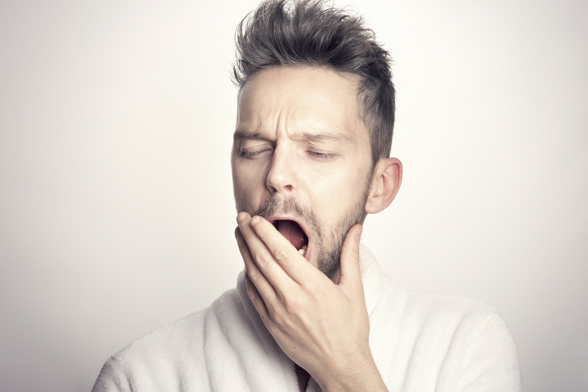 A man covering his mouth while yawning | Photo: Pixabay/Sammy-Williams