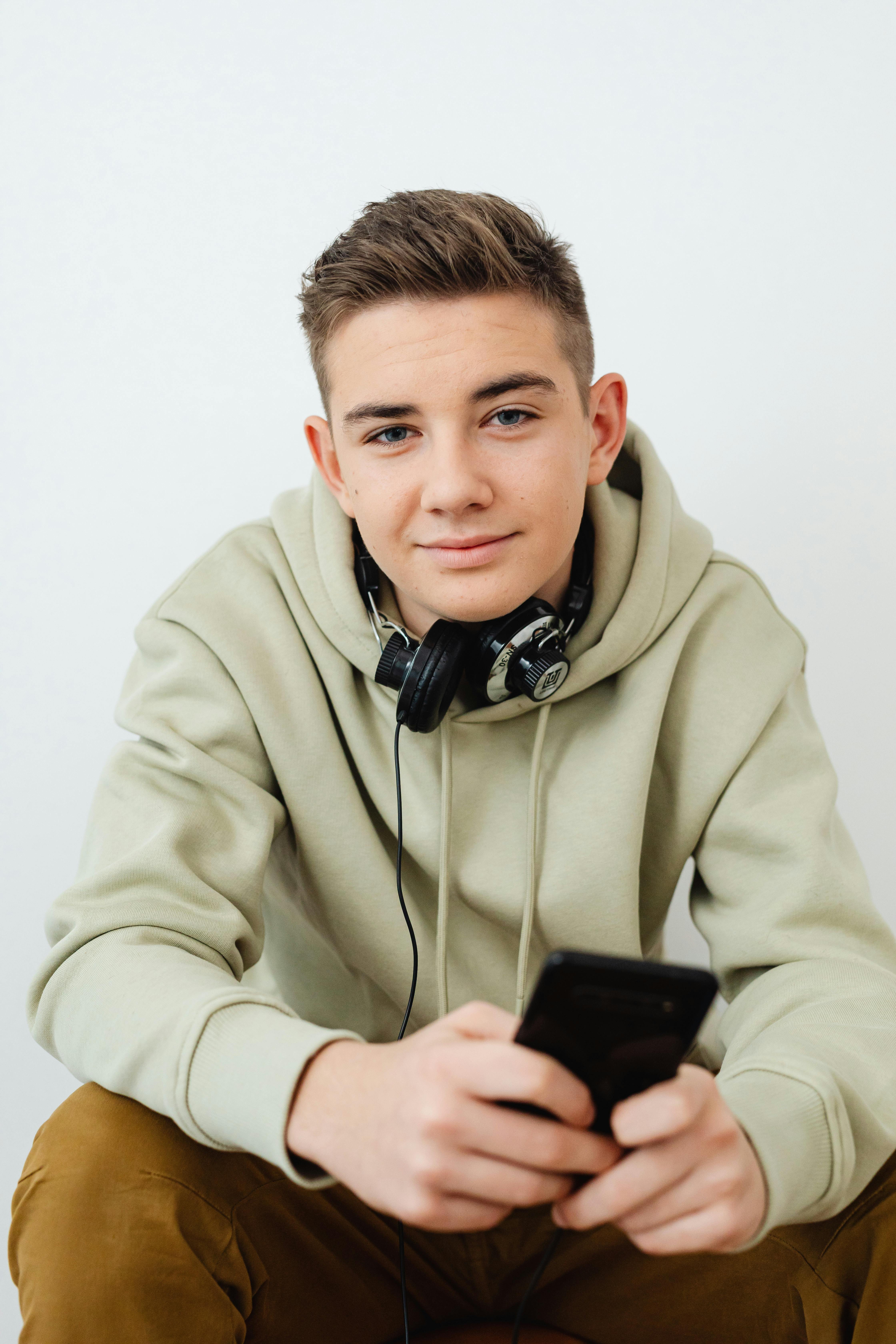 A smiling teenage boy with a phone | Source: Pexels