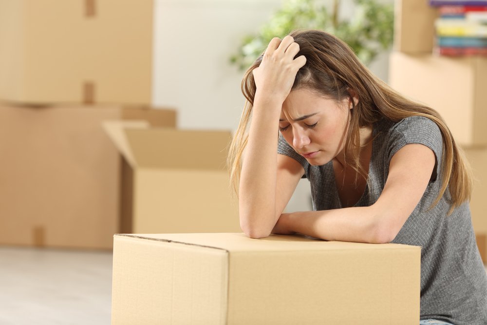 Mujer preocupada sobre las cajas de la mudanza. | Foto: Shutterstock