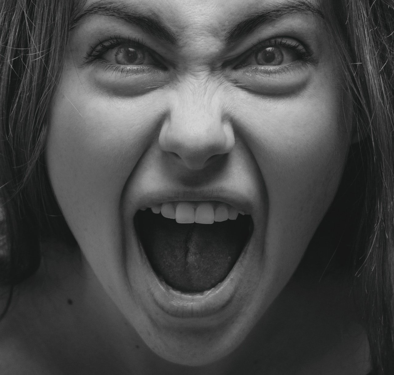 Una joven mujer parece gritar con furia. | Foto: Pexels