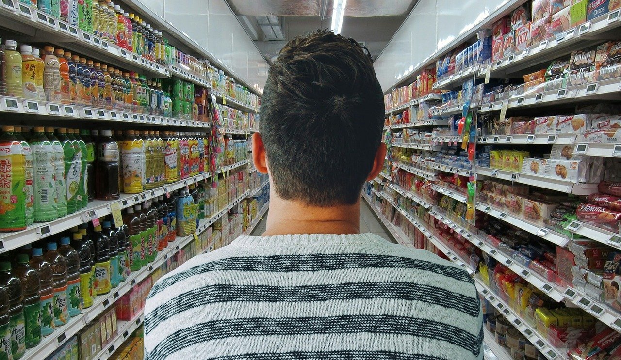 Hombre de espaldas en un corredor de supermercado. | Foto: Pixabay