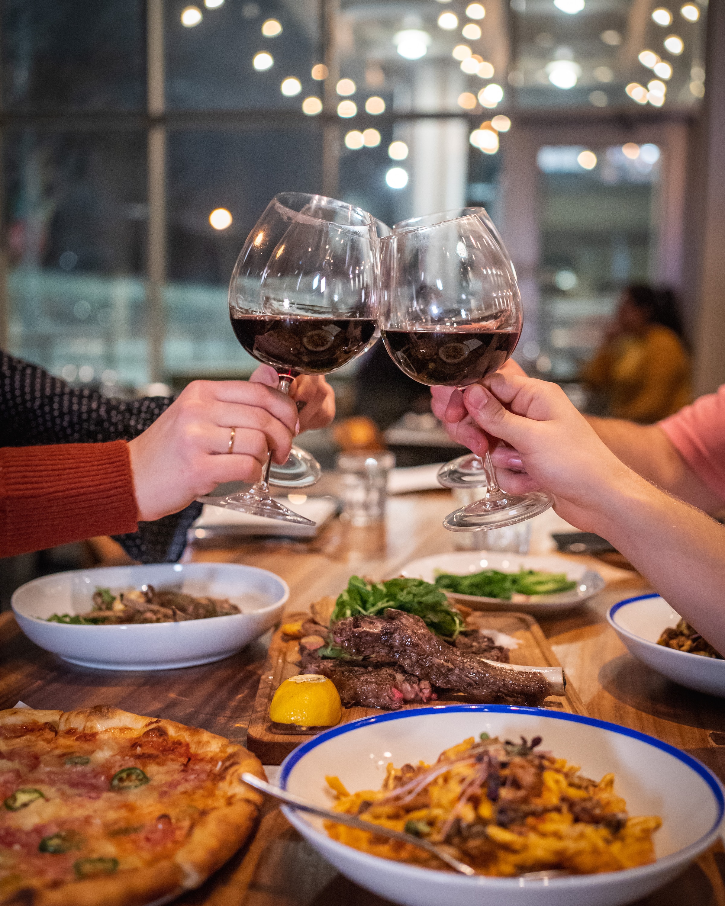 Glasses raised during a meal | Source: Unsplash