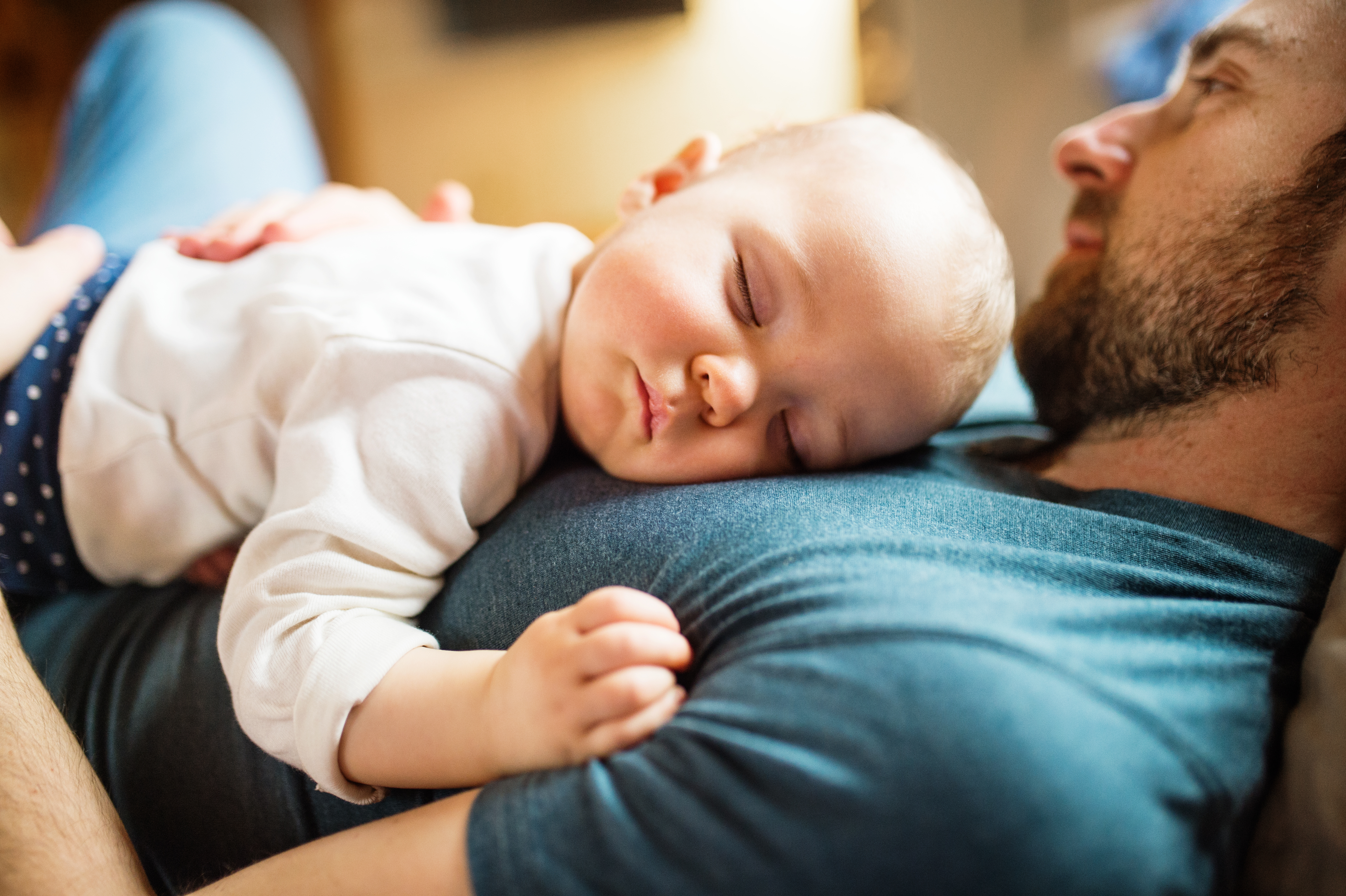 A baby sleeping on a man's chest | Source: Shutterstock