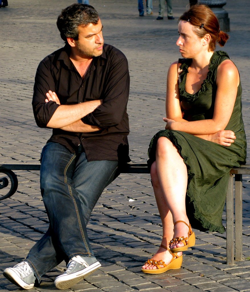 Pareja discutiendo sentada en una banquilla. | Imagen: Flickr