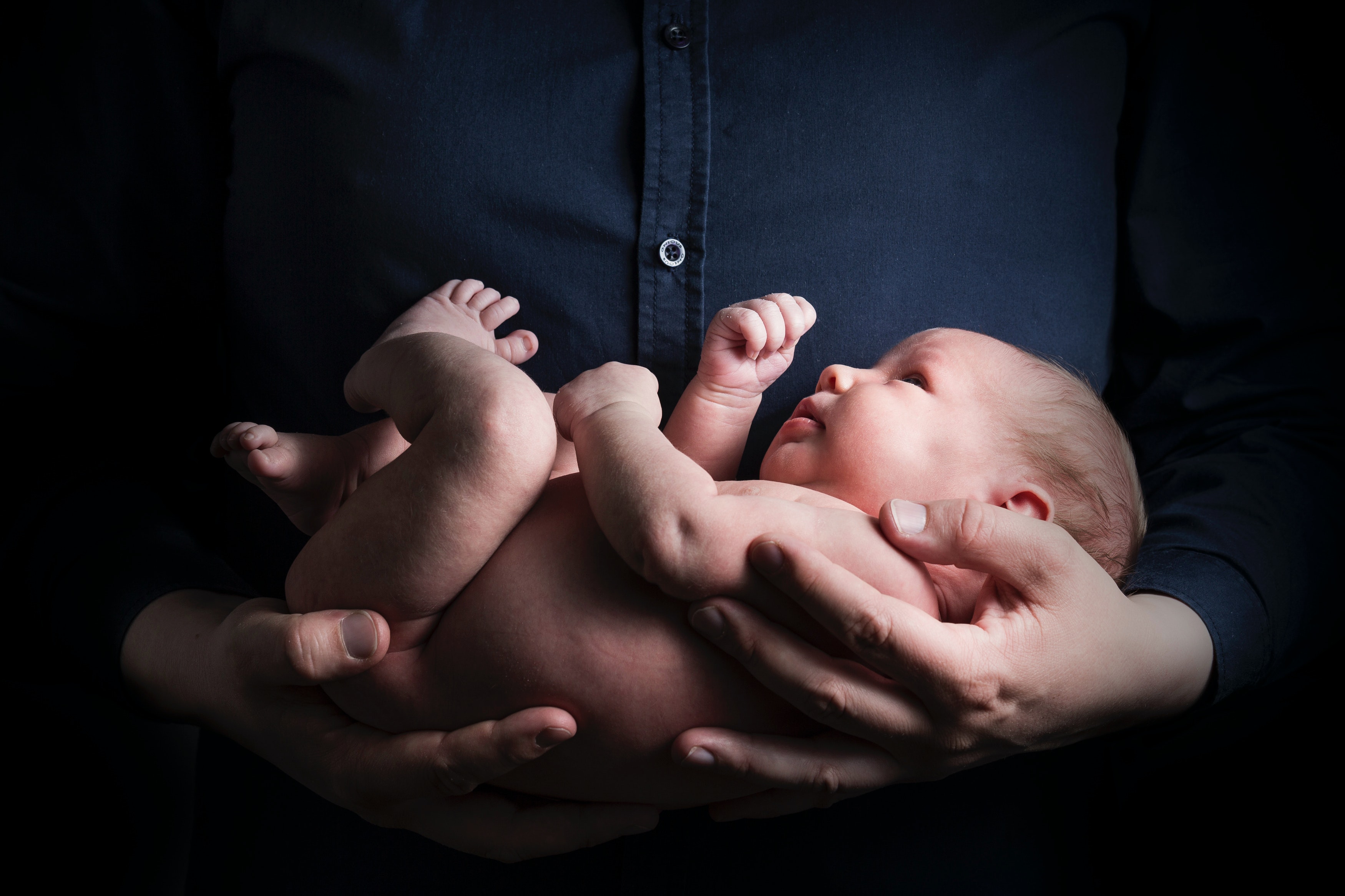 A man holding a newborn baby | Source: Pexels