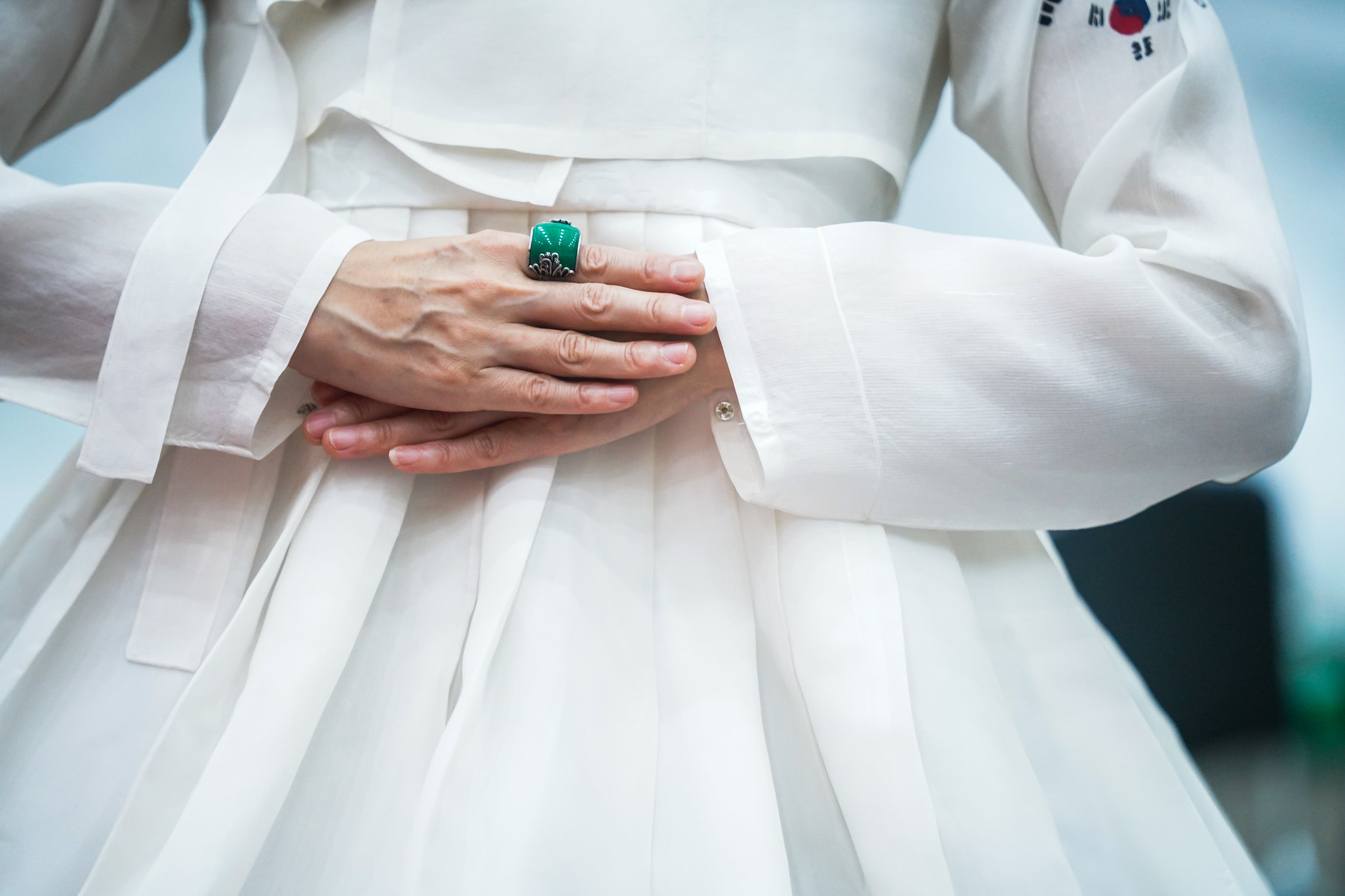 A woman in a white Hanok wearing an emerald ring | Source: Pexels