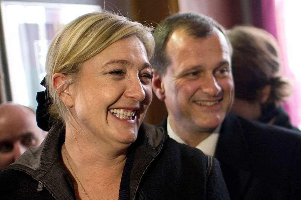 Marine Le Pen flanquée de son compagnon et directeur des opérations et porte-parole Louis Aliot , visite un restaurant dans le centre ville de Sens, au sud de Paris, le 19 avril 2012. | Photo : Getty Images