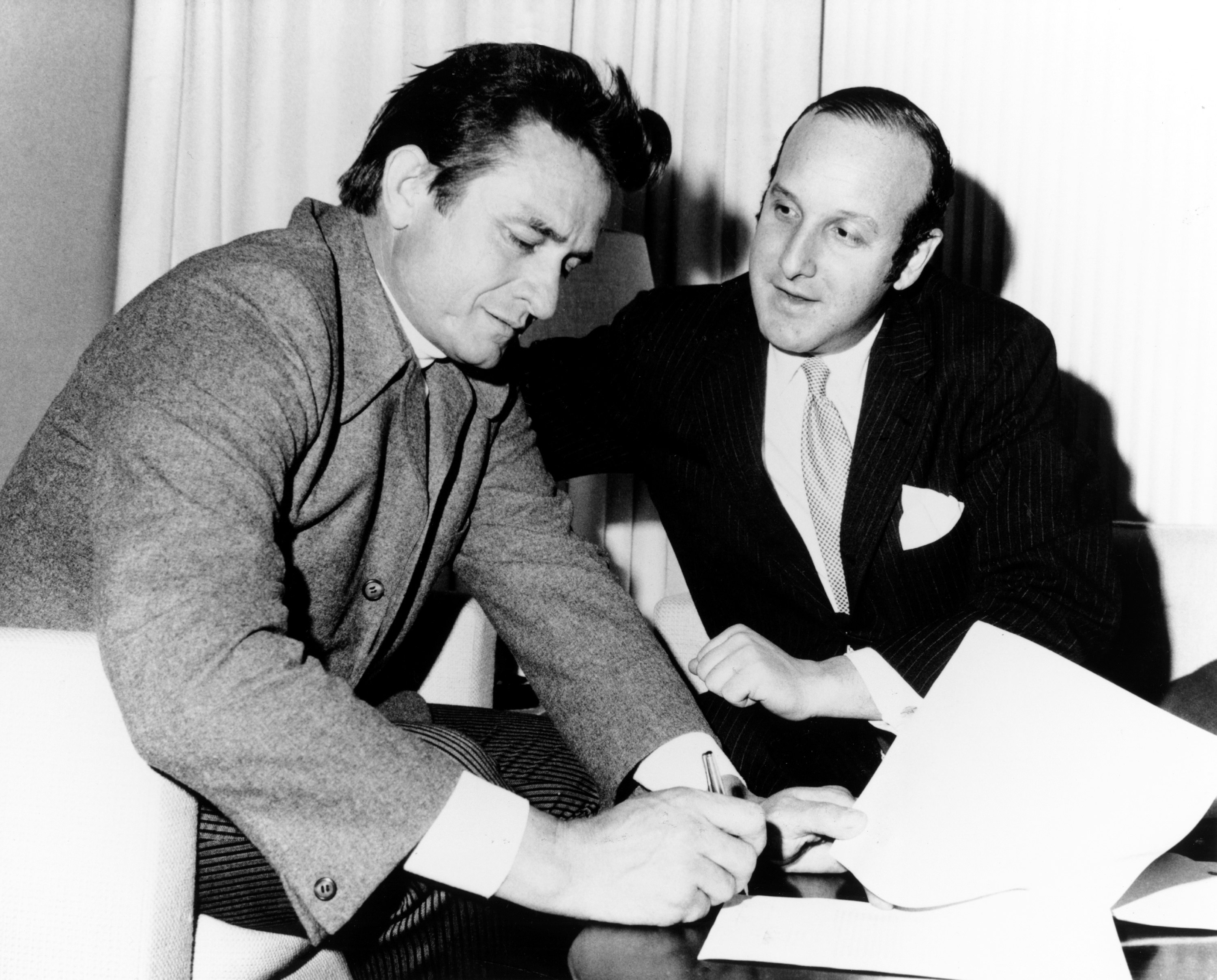 The Brooklyn native became an attorney for the label. On this occasion, Johnny Cash signed a record contract with Columbia Records lawyer Clive Davis in circa 1960. | Source: Getty Images