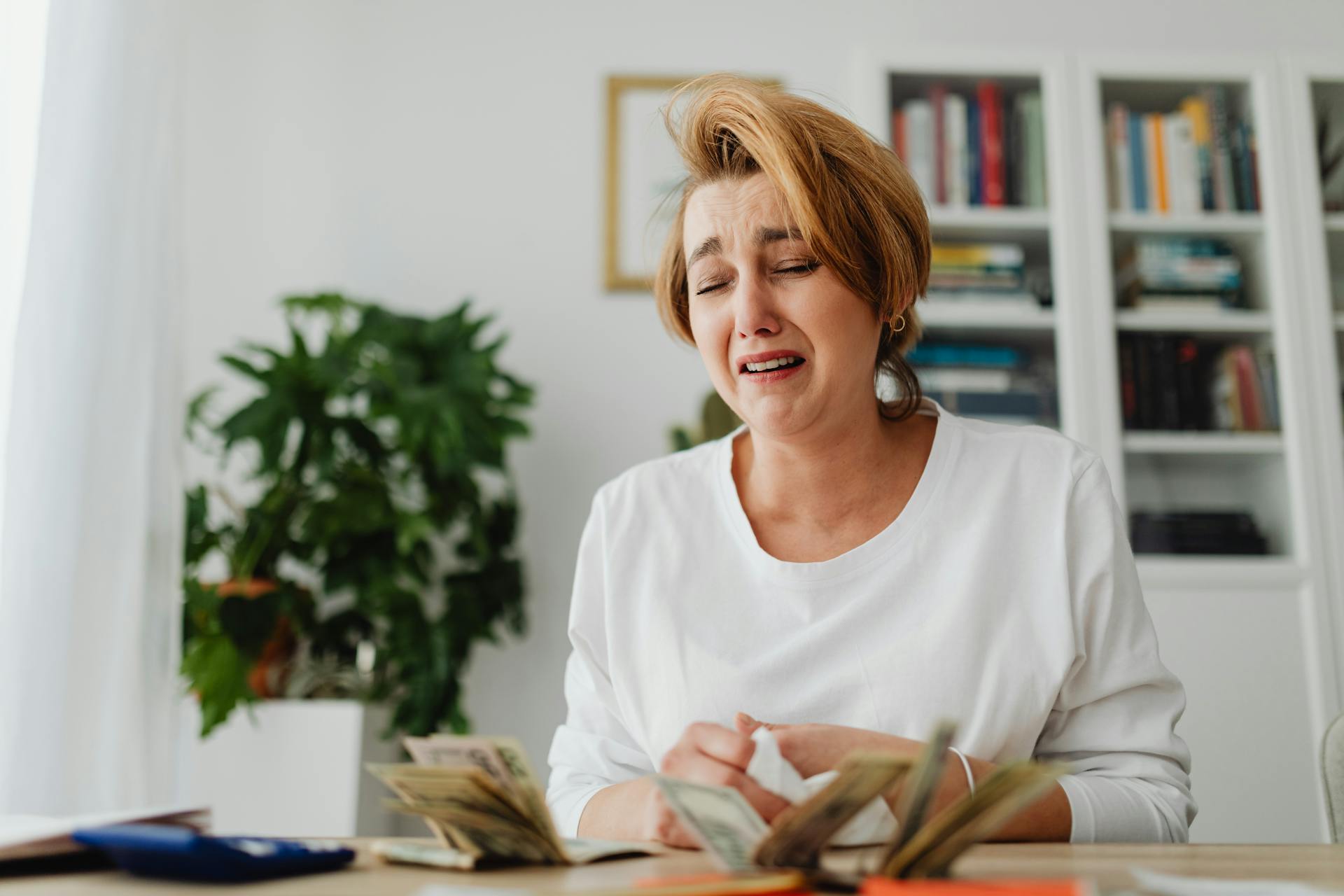 A woman counting money and crying | Source: Pexels