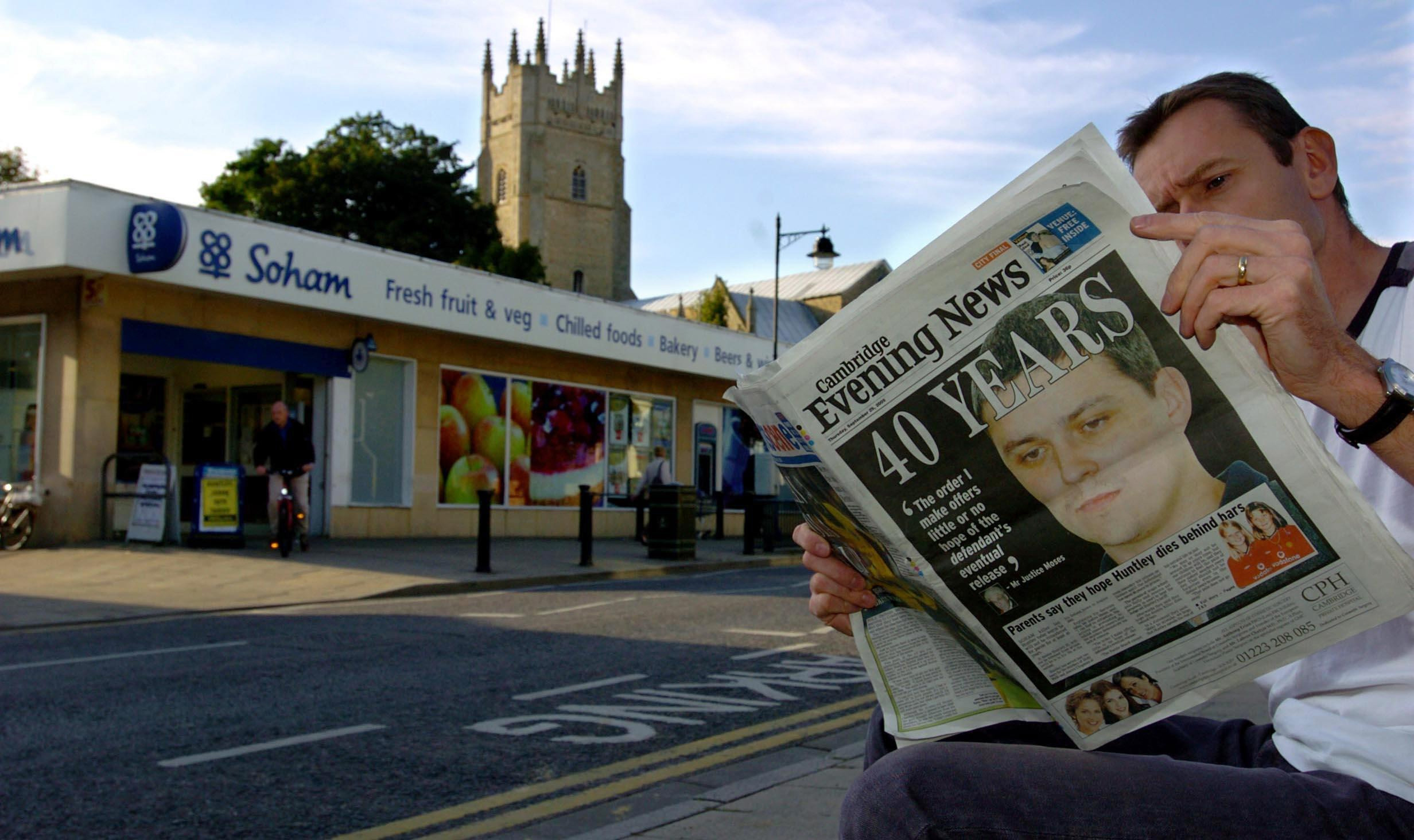 A man reads the Cambridge Evening News in Soham Village, Cambridgeshire, England, on September 29, 2005, after it was announced that Soham murderer Ian Huntley would serve a minimum of 40 years for the murder of Jessica Chapman and Holly Wells. | Source: Getty Images