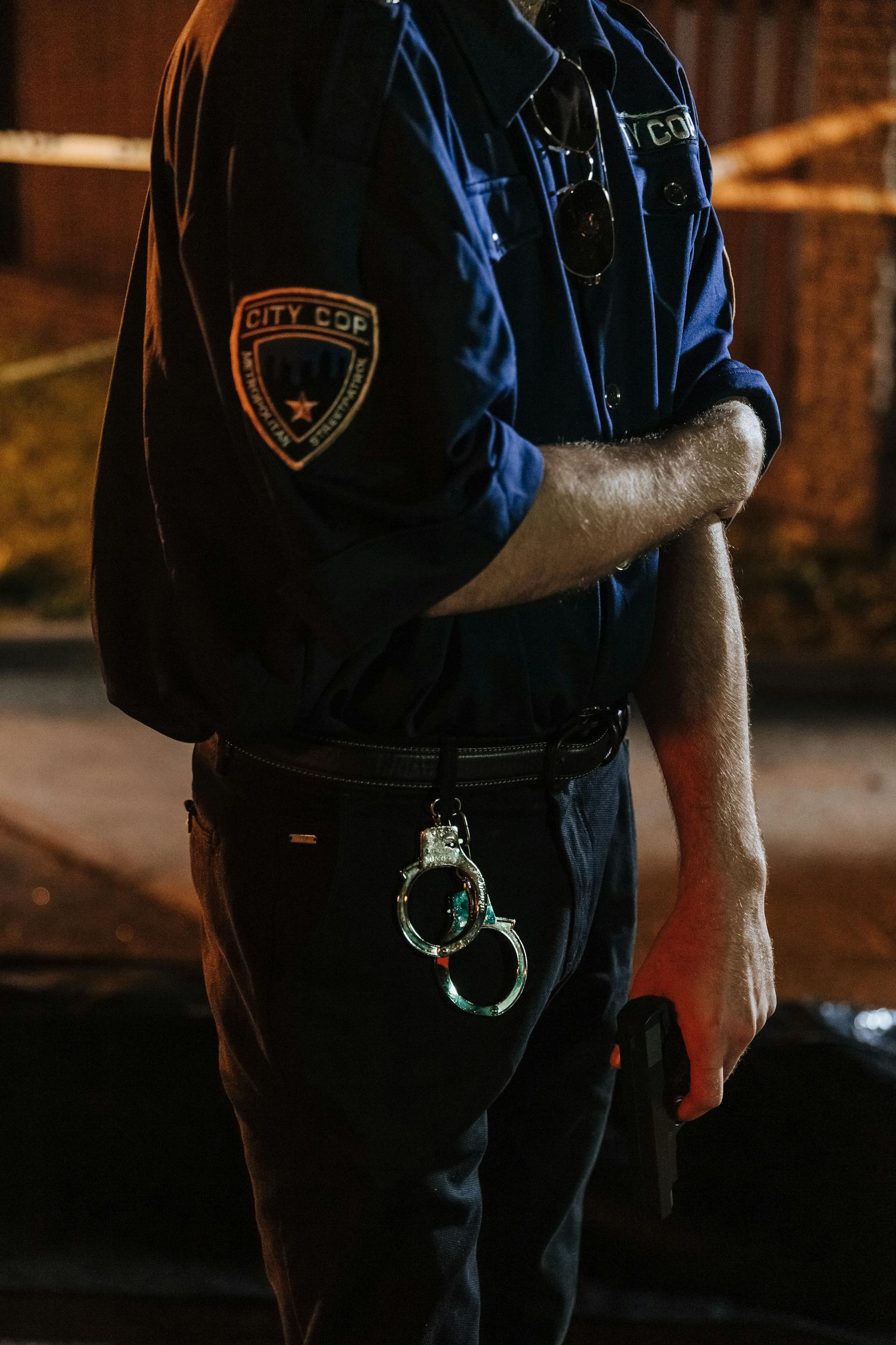 Handcuffs hanging from a police officer's pants | Source: Midjourney