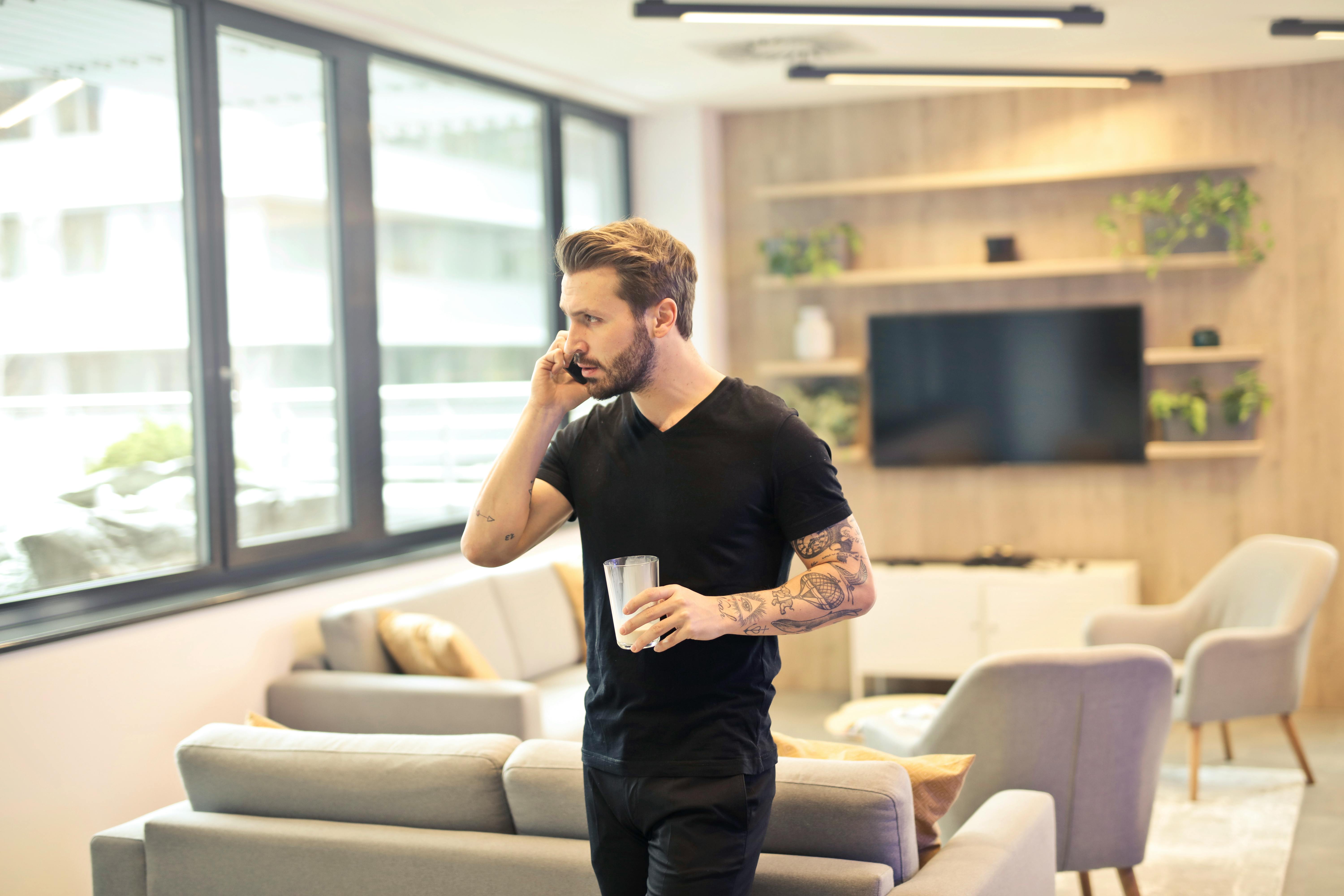 A man holding a beverage while talking on the phone | Source: Pexels
