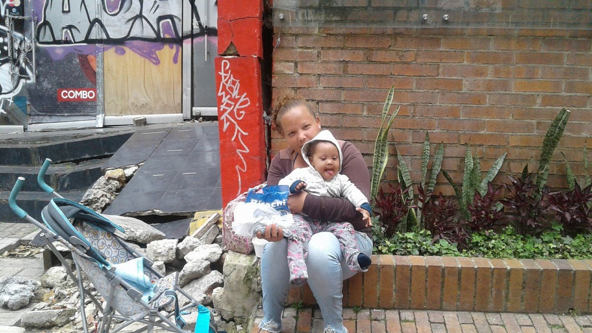 Imagen referencial. Mujer sin hogar sentada con su hija sobre su regazo en una acera. | Foto: PxHere Imagen referencial. Mujer sin hogar sentada con su hija sobre su regazo en una acera. | Foto: PxHere