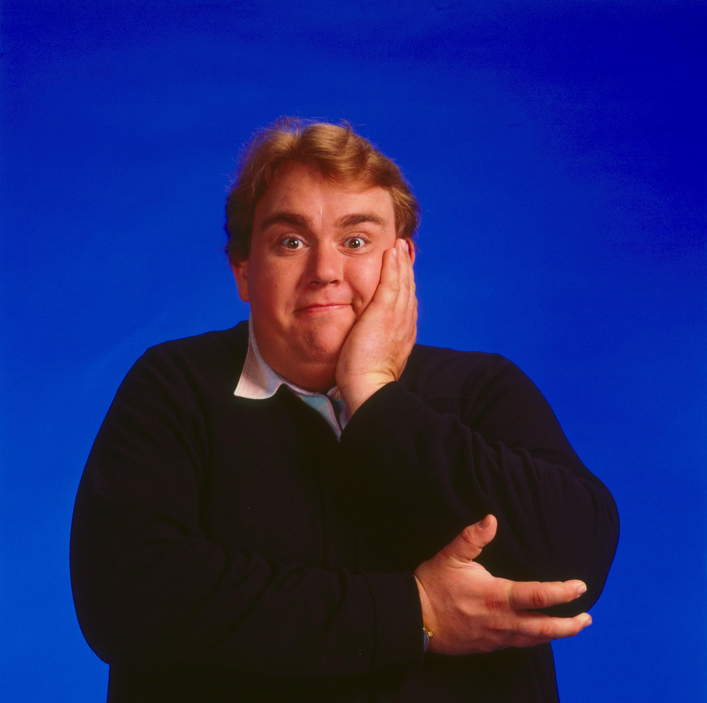 Canadian actor John Candy (1950 - 1994) poses for a portrait against a blue background to promote the film "Delirious" (directed by Tom Mankiewicz) in Los Angeles, California, circa 1990. | Source: Getty Images