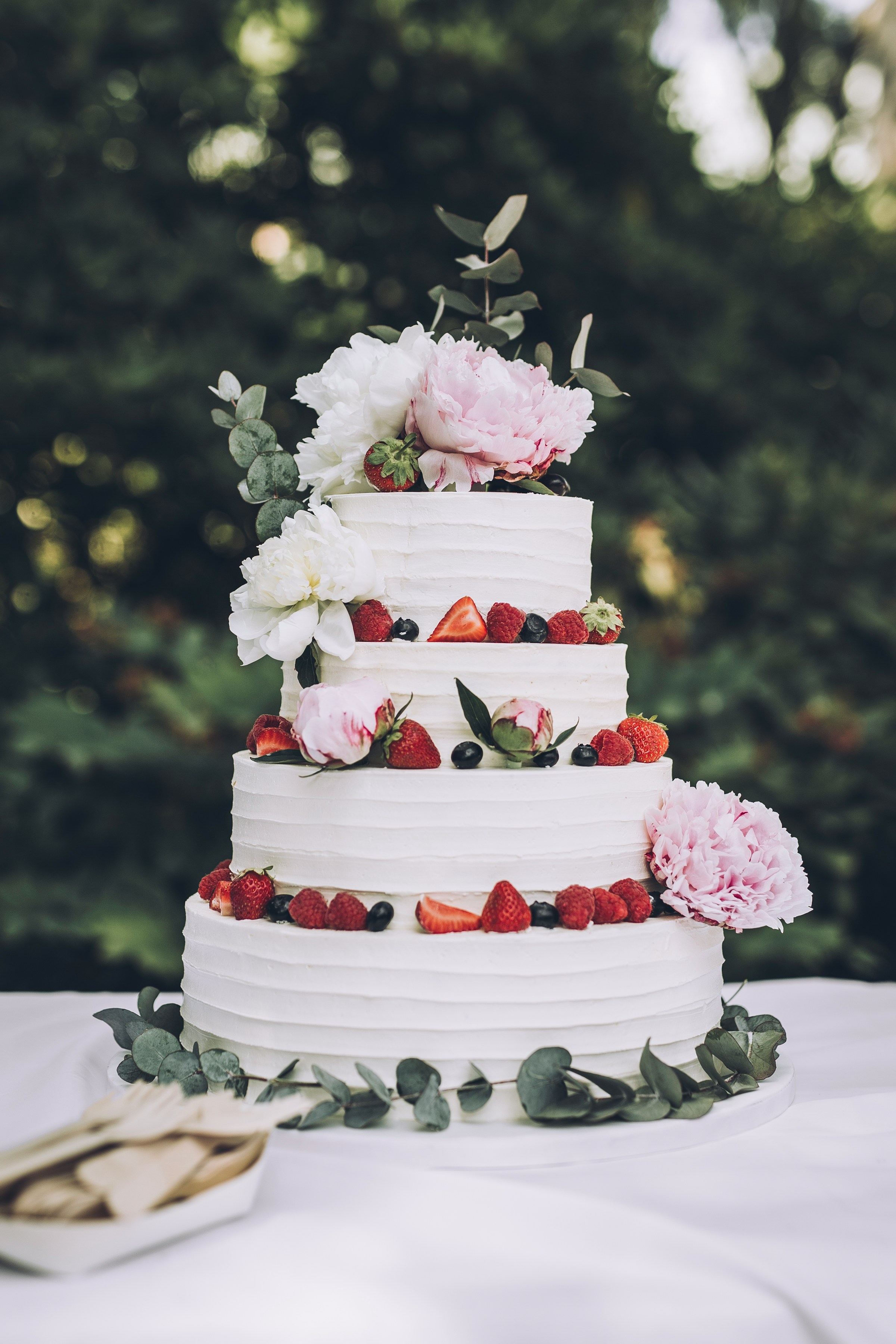 Um bolo de casamento branco com frutas | Fonte: Unsplash