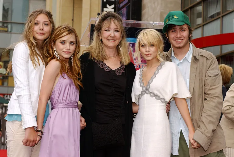 Les Olsen : Elizabeth, Mary-Kate, sa mère Jarnette, Ashley et son frère Trent Olsen, lors de la cérémonie au cours de laquelle Ashley et Mary-Kate ont reçu une étoile sur le Hollywood Walk of Fame en 2004. | Photo : Getty Images