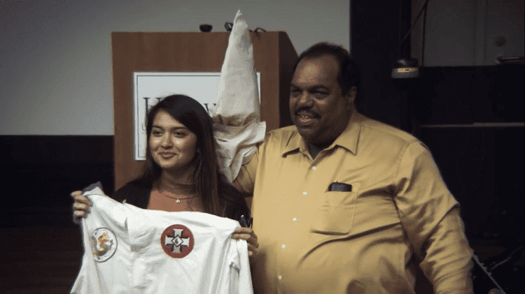 Daryl Davis posing with a lady while holding Ku Klux Klan attire shown in the trailer of the documentary film "Accidental Courtesy" | Source: YouTube/Accidental Courtesy
