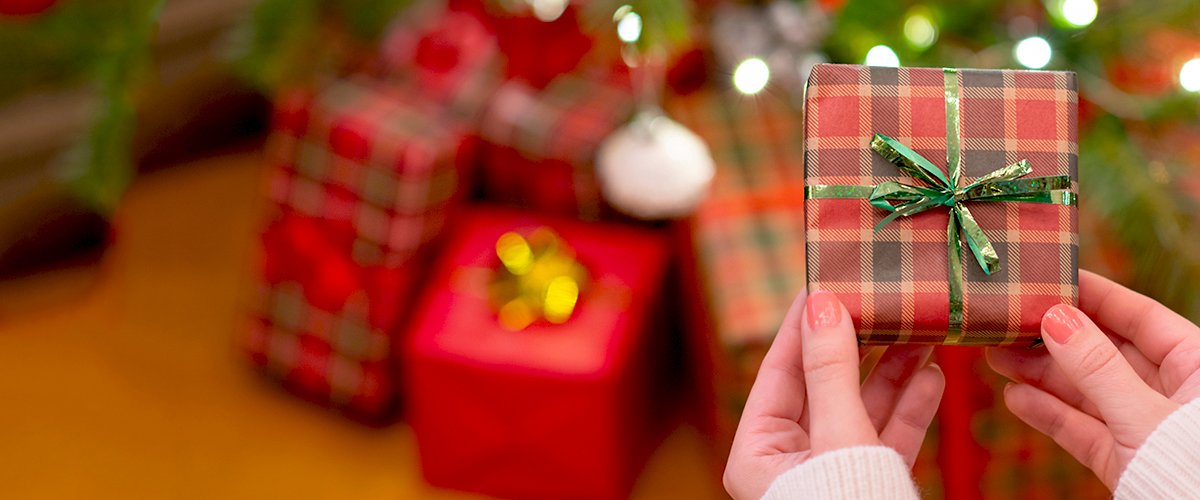 Manos con un regalo de Navidad. | Foto: Shutterstock
