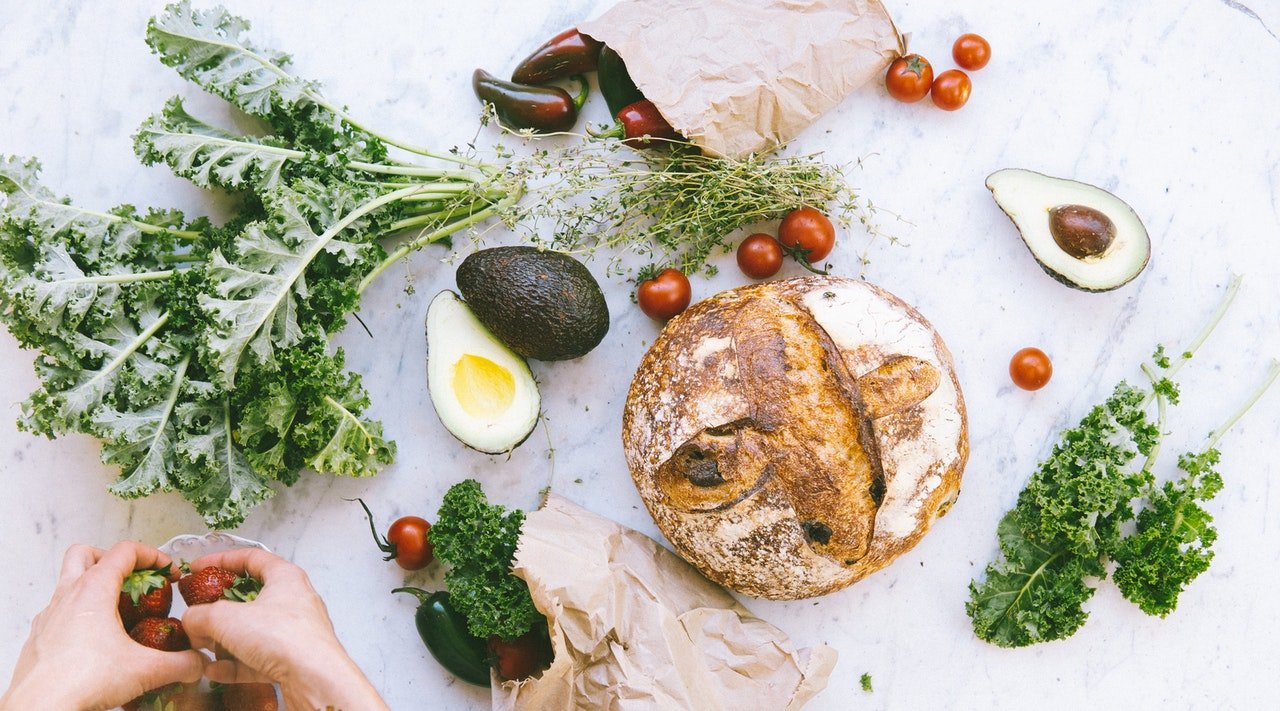 Photo of bread, tomatoes and avocados on a work board | Photo: Pexels