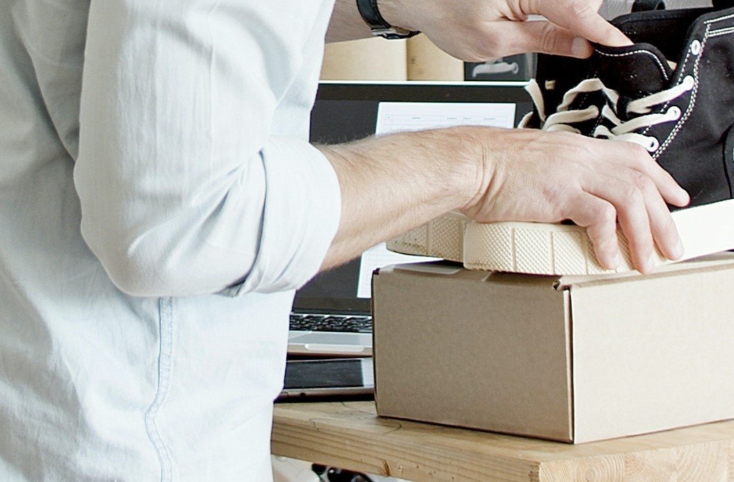 A man checking sneakers placed on top of a shoe box | Source: Pexels