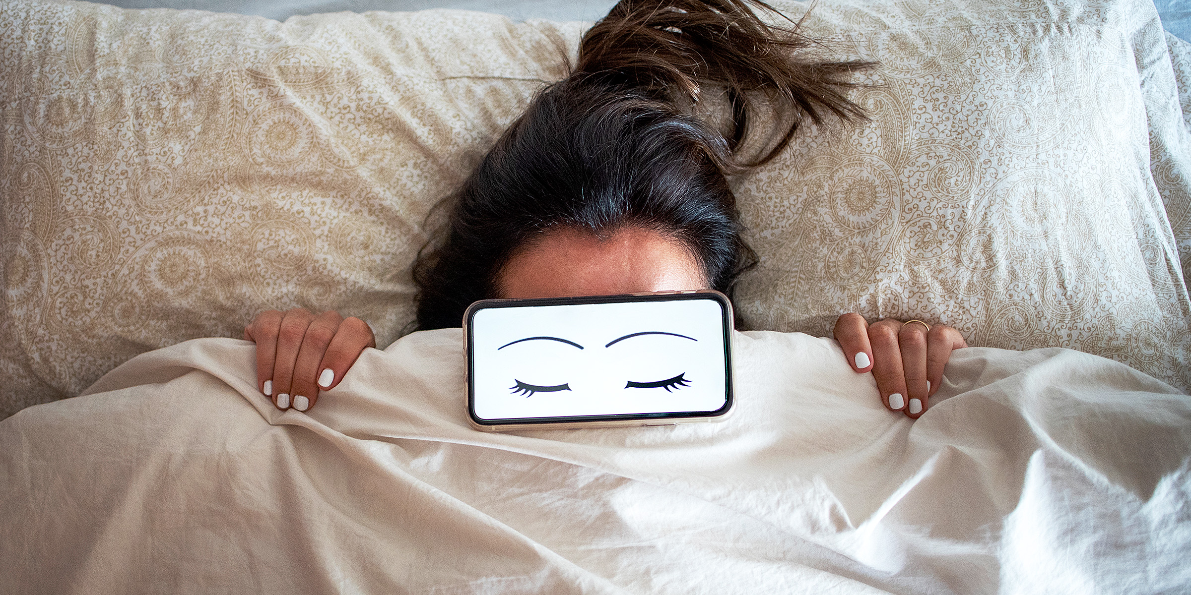 A woman in bed with cartoon eyes over her face | Source: Getty Images