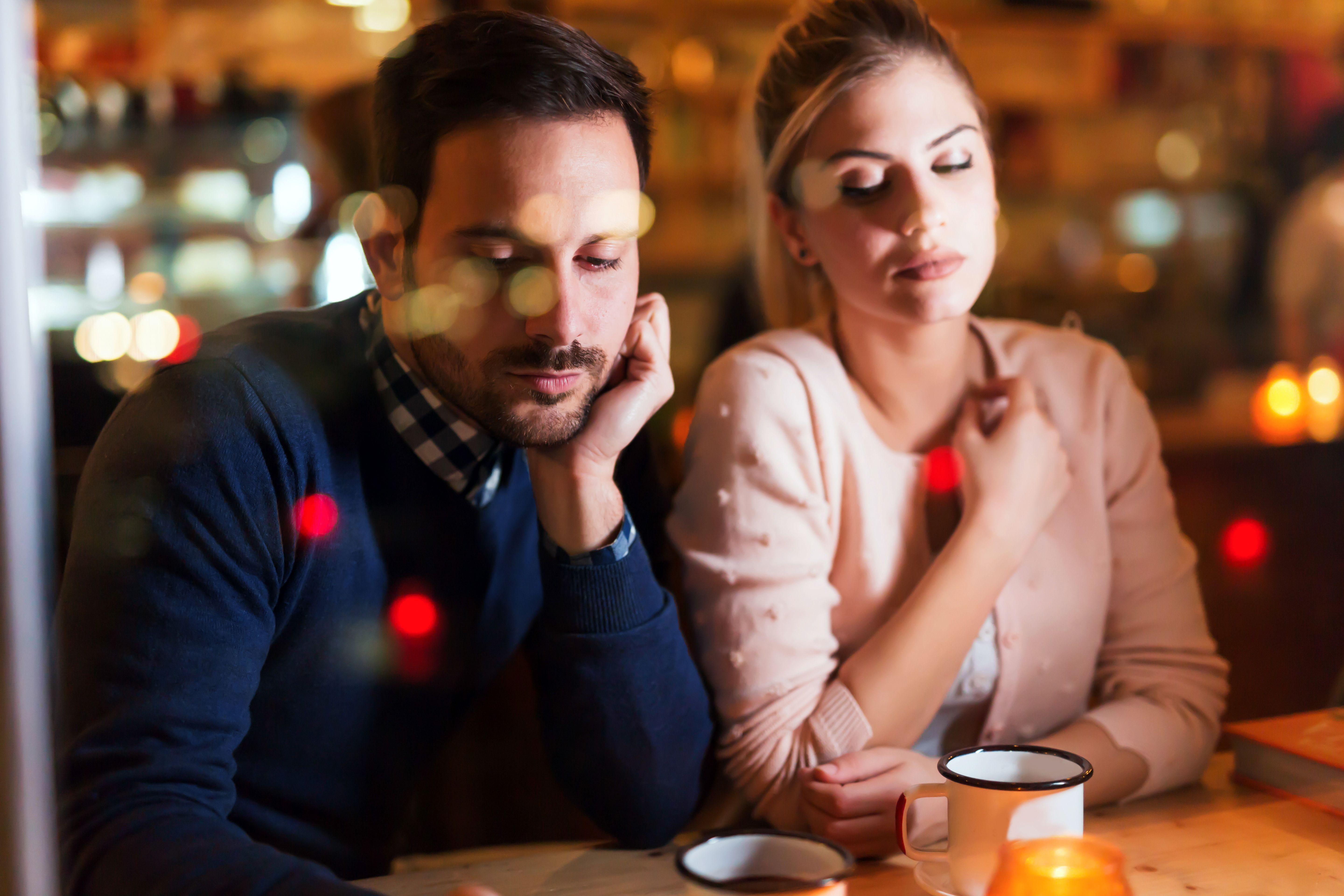 A bored couple in a cafe, showing signs of jealousy. | Source: Shutterstock