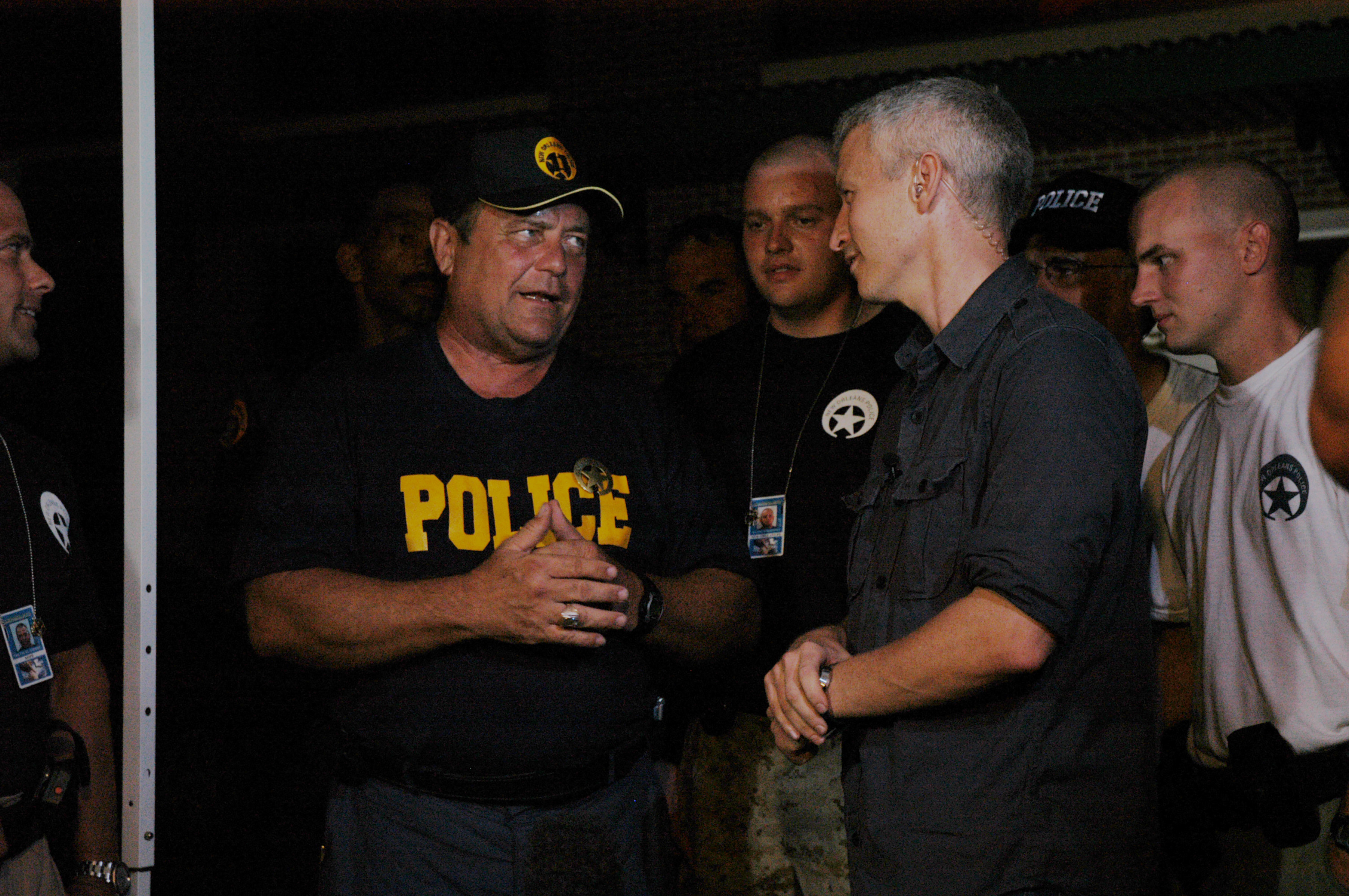 Anderson Cooper talks with members of the New Orleans Police Department to learn more information for his reports from the aftermath of Hurricane Katrina on September 18, 2005 | Source: Getty Images