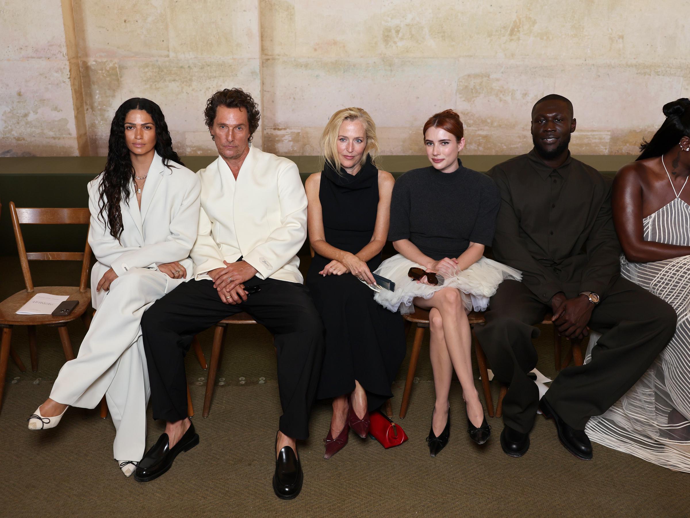 Alves, McConaughey, Gillian Anderson, Emma Roberts, and Stormzy are seated front row at the Jacquemus fashion show, ready for the event to begin. The seating arrangement, placing Anderson between McConaughey and Roberts, caught fans' attention, with many suggesting it should have been adjusted to allow smoother conversation between the two actors.