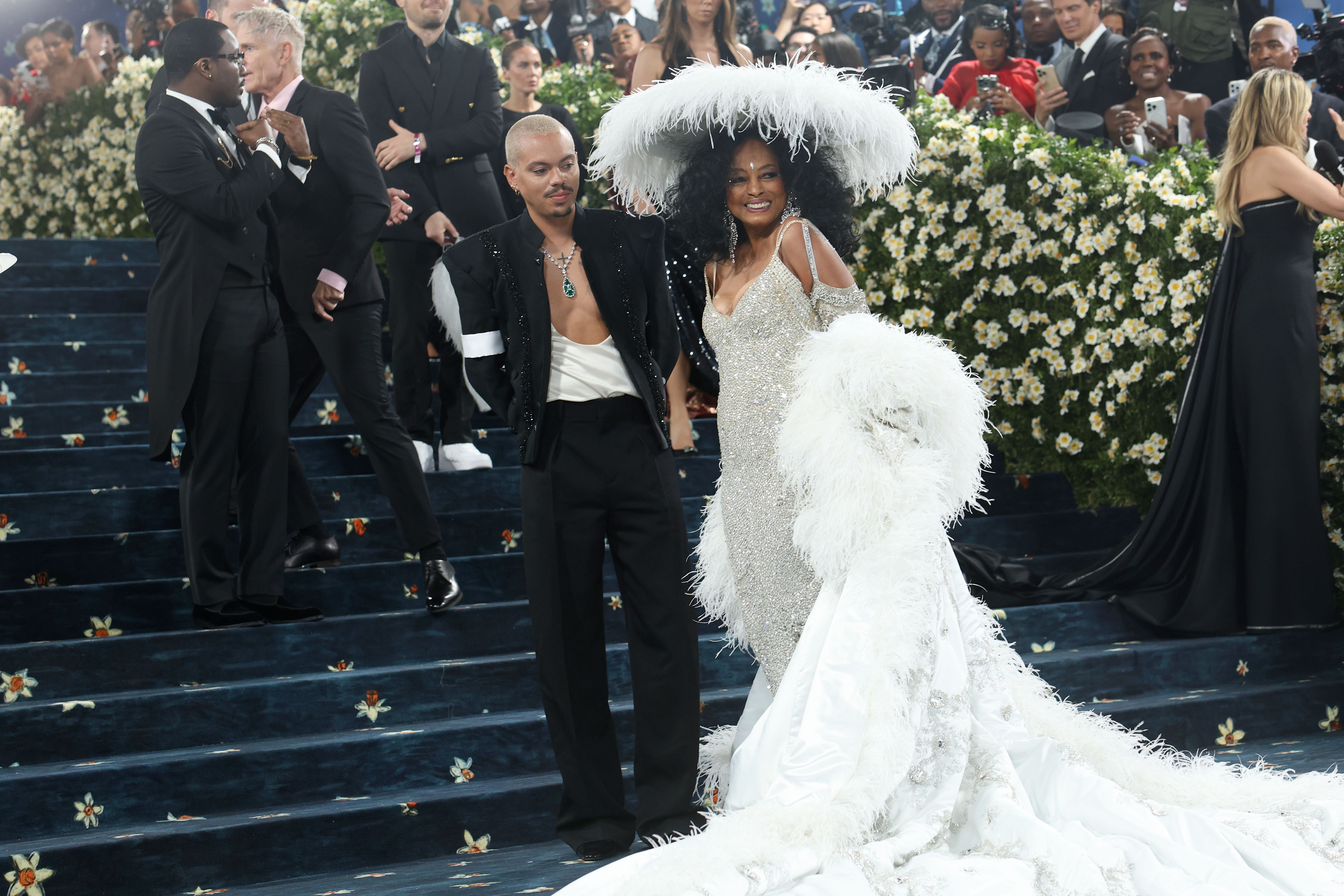 In this shot, Ross and her son stand side by side, their presence commanding the frame. Though people fill the background behind them, it's nearly impossible to focus on anyone else, their aura, style, and beauty eclipse the crowd.