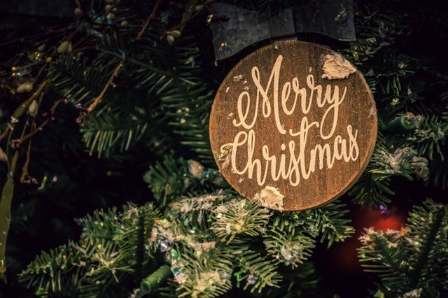 Merry Christmas sign on a Christmas tree | Source: Pexels