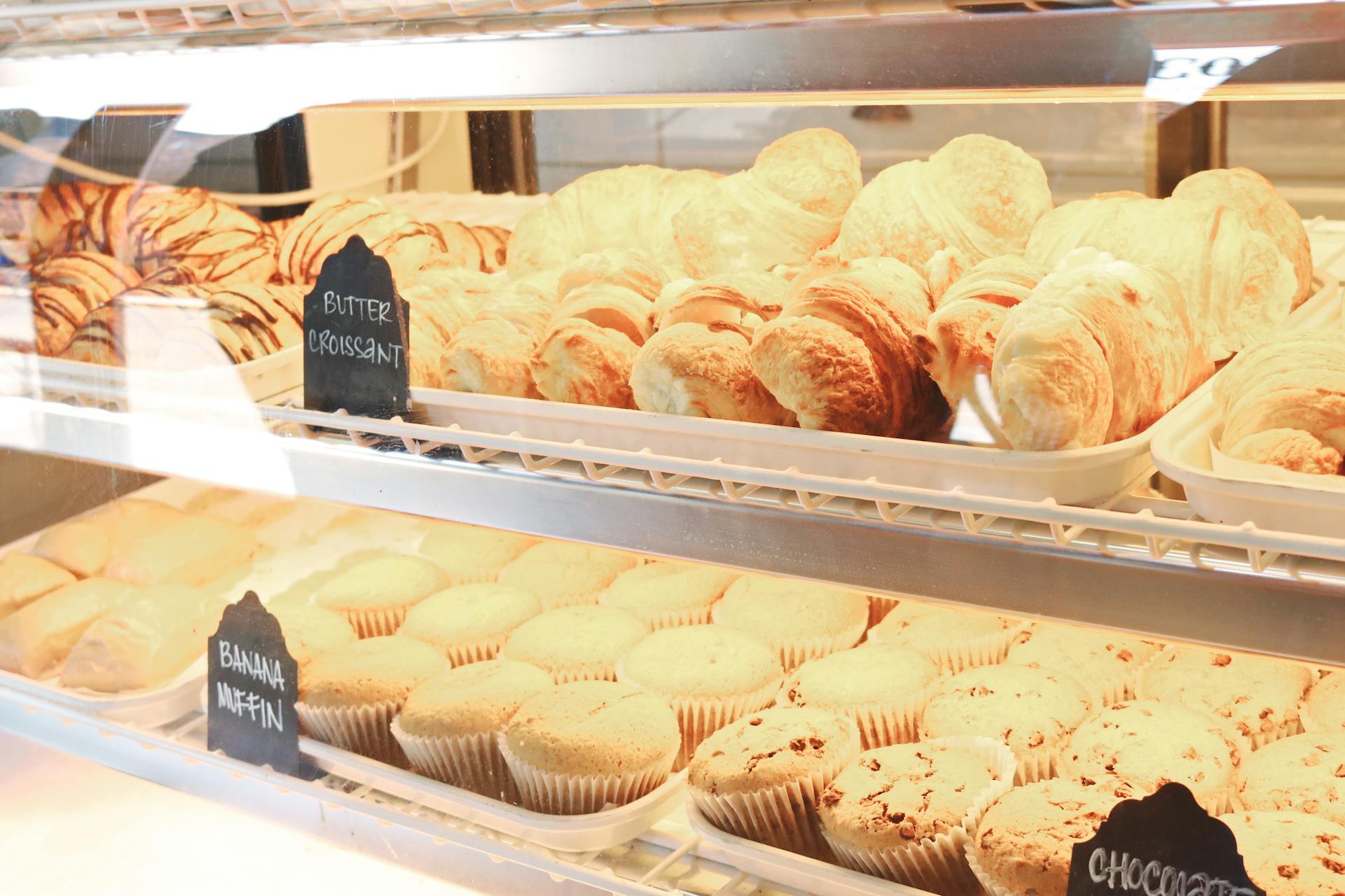 Croissants and muffin displayed in a bakery | Source: Pexels