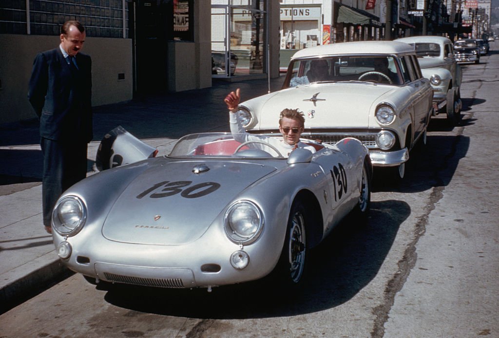 Schauspieler James Dean gibt ein Daumen hoch-Zeichen von seinem Porsche 550 Spyder, dem kleinen Bastard, während er in der Vine Street in Hollywood geparkt ist |  Quelle: Corbis über Getty Images