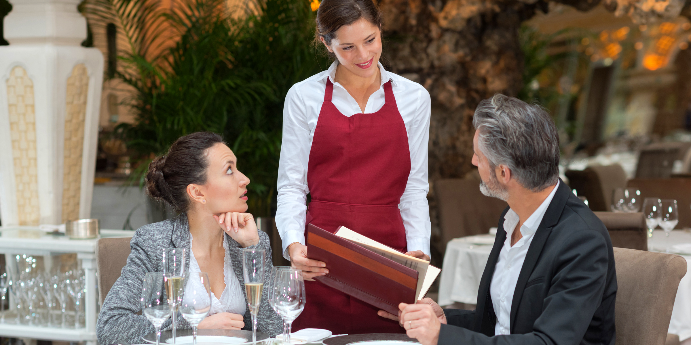 A couple at a restaurant with a waitress | Source: Shutterstock