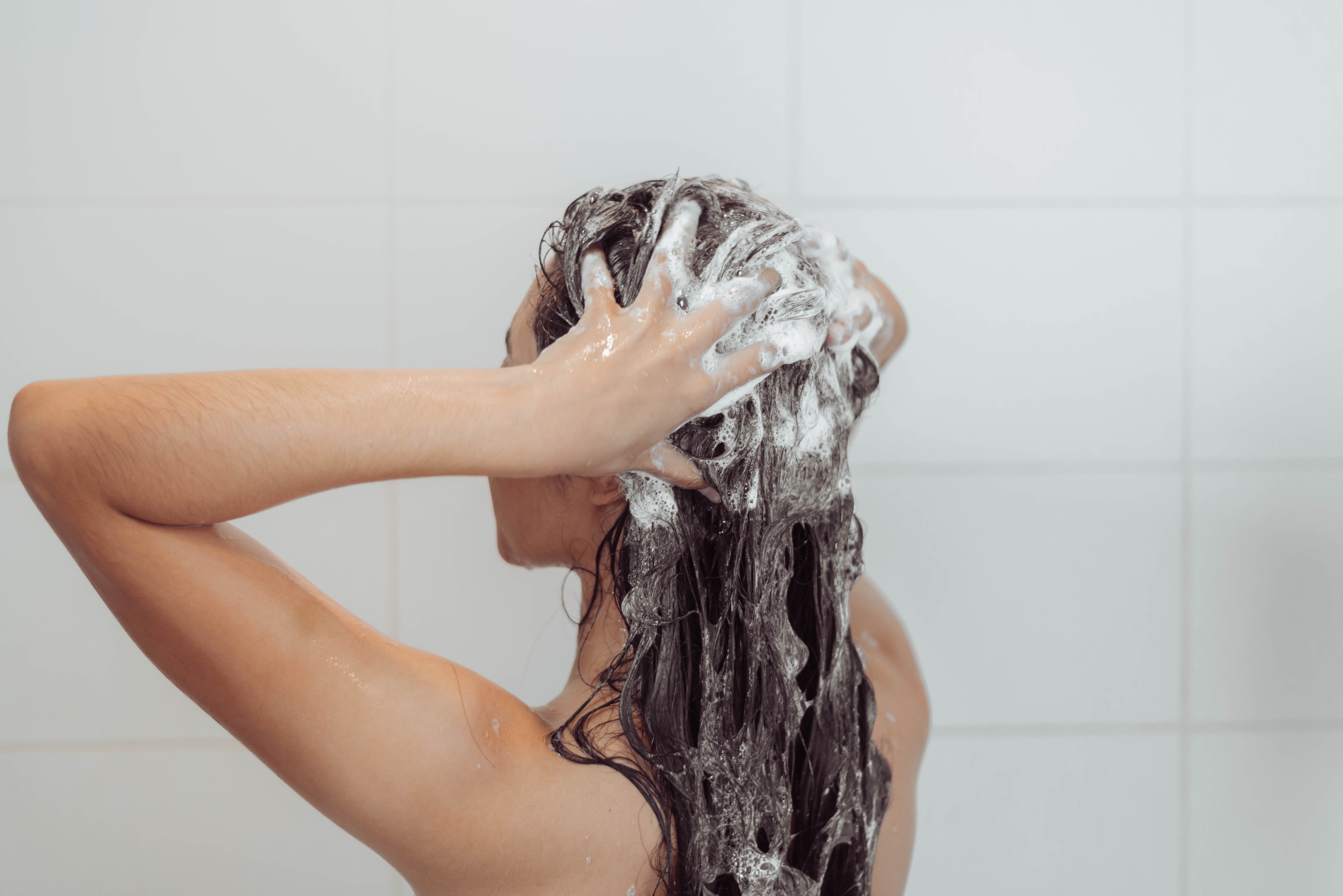 Woman washing  her hair | Source: Shutterstock