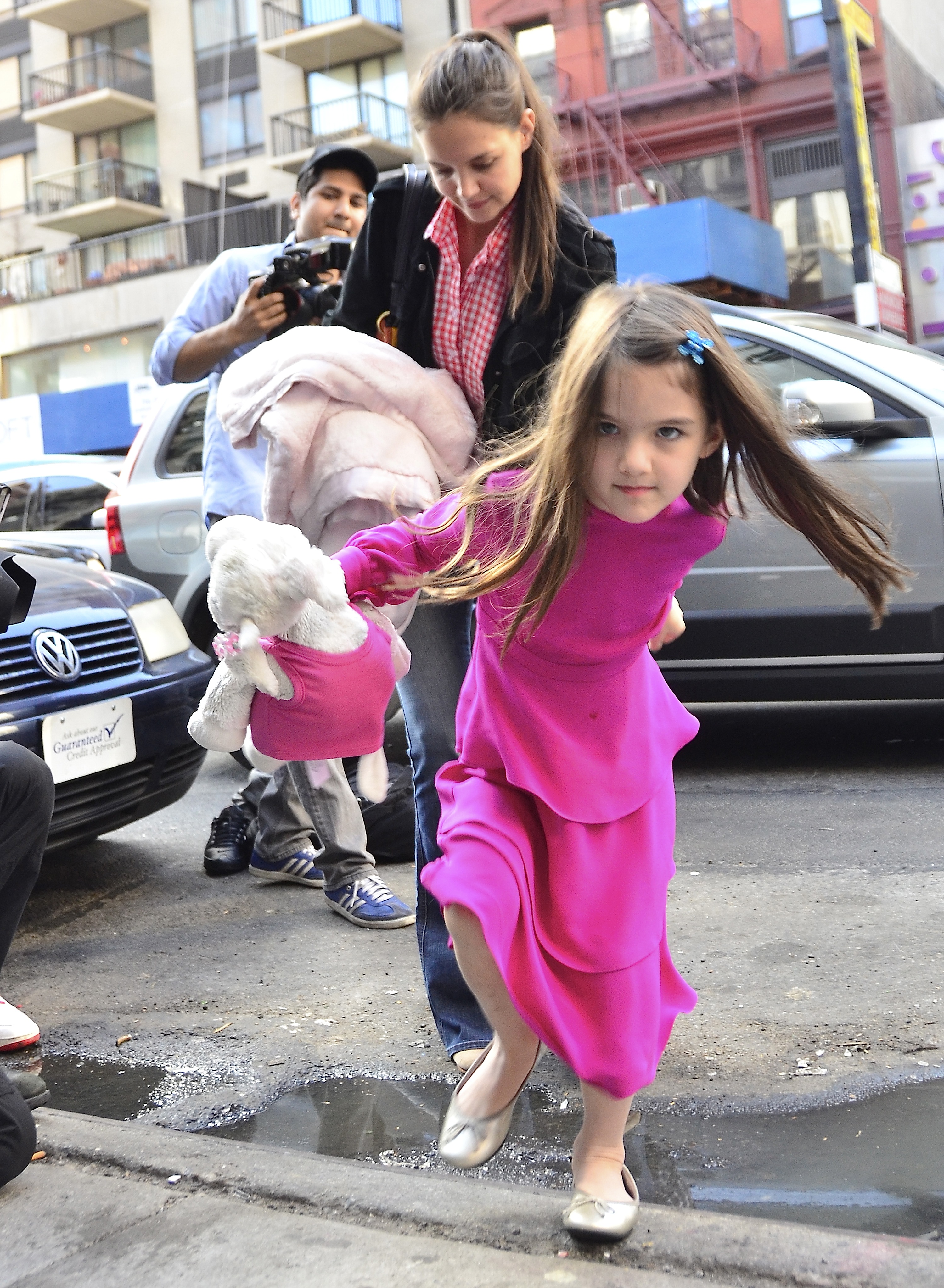 Katie Holmes and Suri Cruise with a paparazzi in the background in New York City on March 20, 2012 | Source: Getty Images