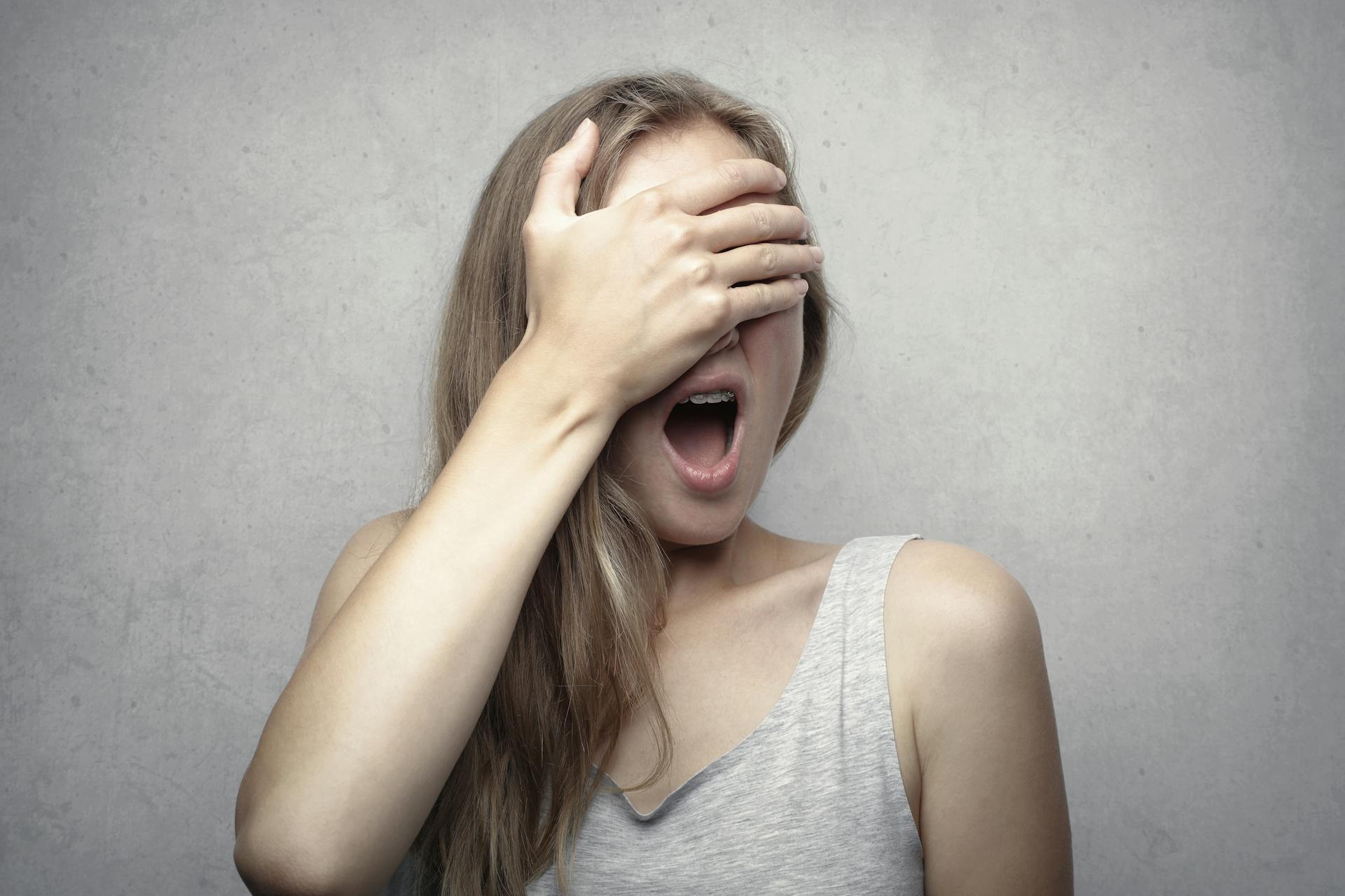 A shocked woman covering her eyes with one hand | Source: Pexels