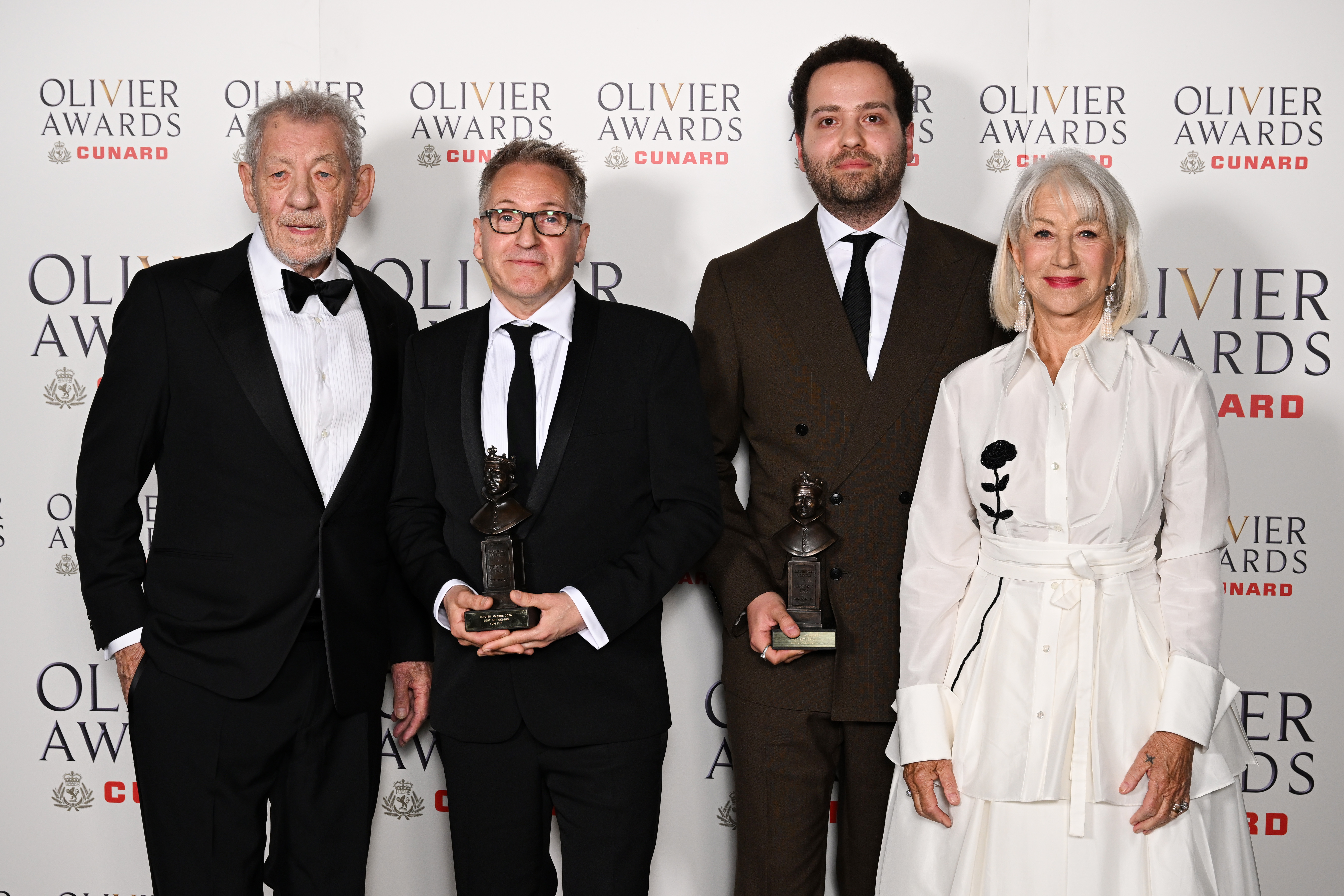Sir Ian McKellen, Tom Pye, Ash J. Woodward, and Dame Helen Mirren pose inside the Winners Room during The Olivier Awards 2026 on 12 April in London, England. | Source: Getty Images