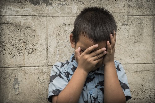 Kleiner Junge vergräbt sein Gesicht in seinen Händen | Quelle: Shutterstock