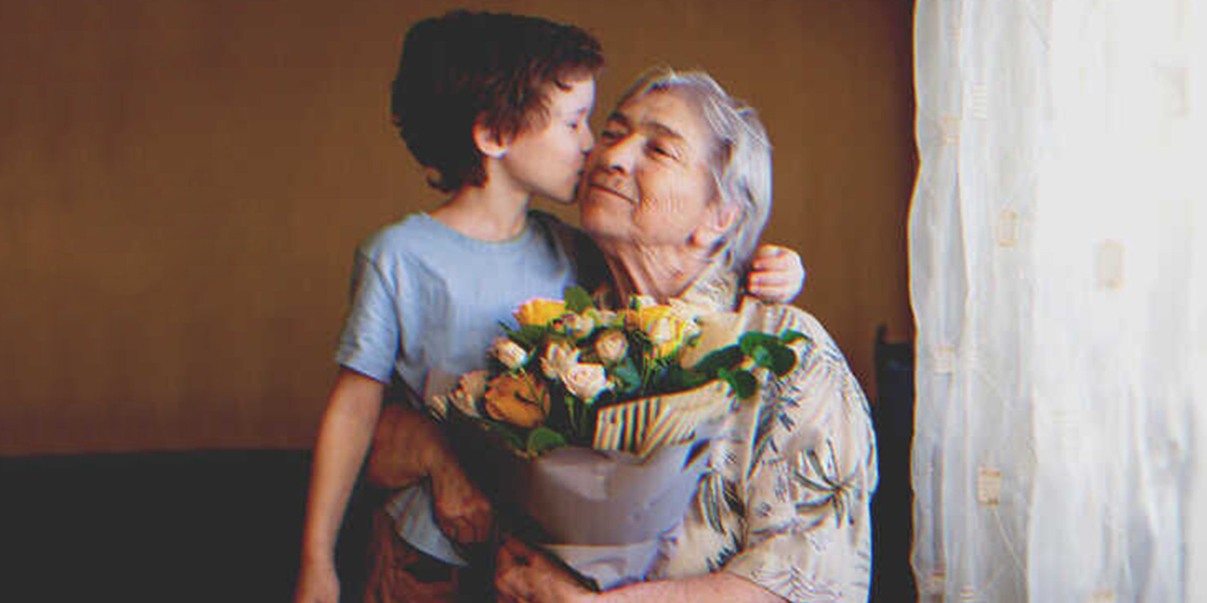 Un enfant qui embrasse sa grand-mère sur la joue І Source : Shutterstock