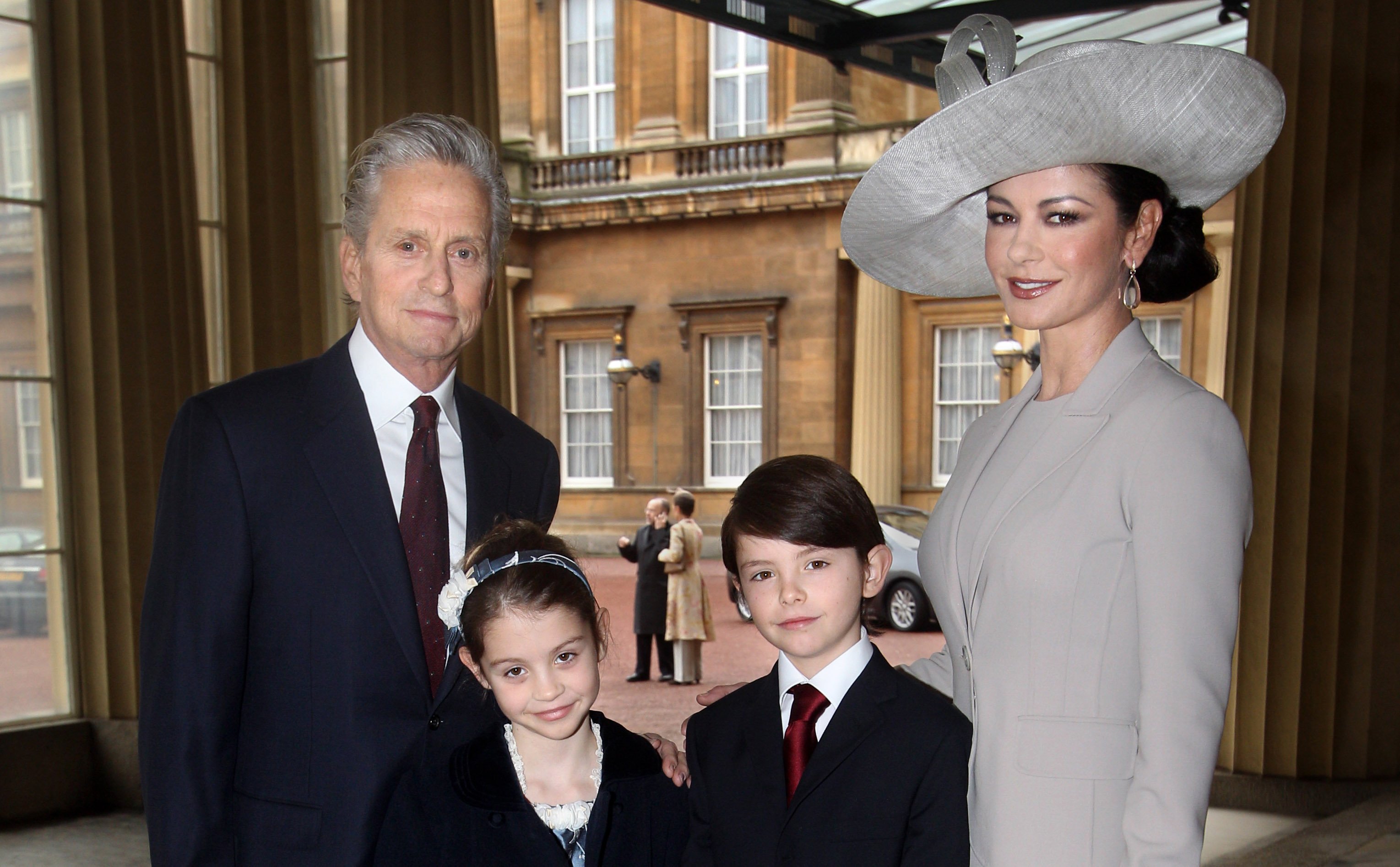 Actress Catherine Zeta-Jones (R) arrives with her husband, actor Michael Douglas and their children Dylan and Carys Douglas, to attend a Royal Investiture at Buckingham Palace on February 24, 2011 in London, England. | Source: Getty Images
