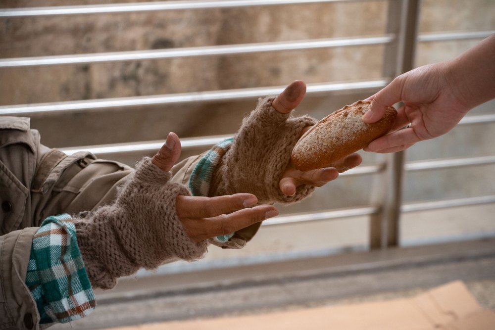 Indigente recibe un pan. | Foto: Shutterstock.