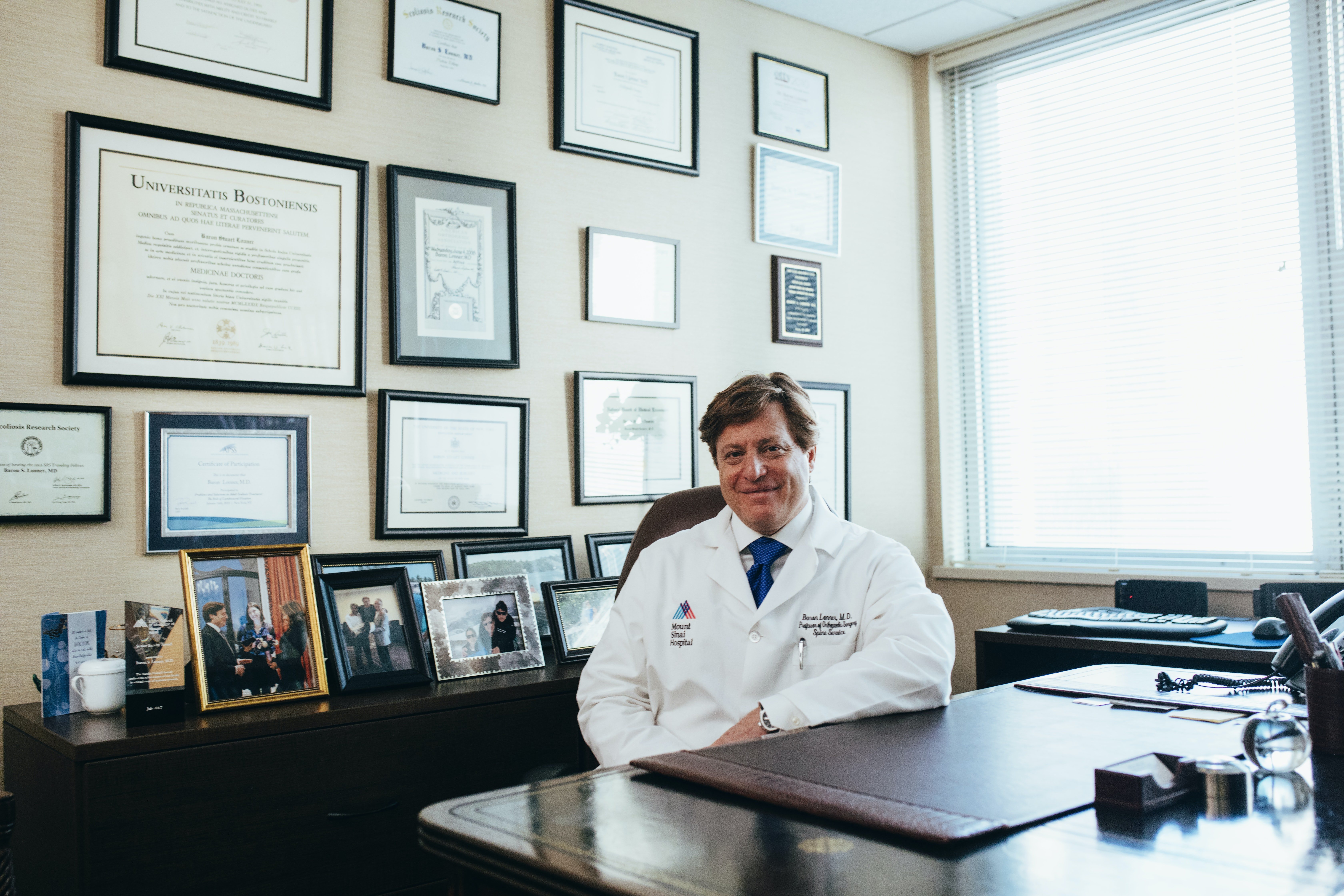 Médico sonriendo y posando desde su escritorio. | Foto: Pexels