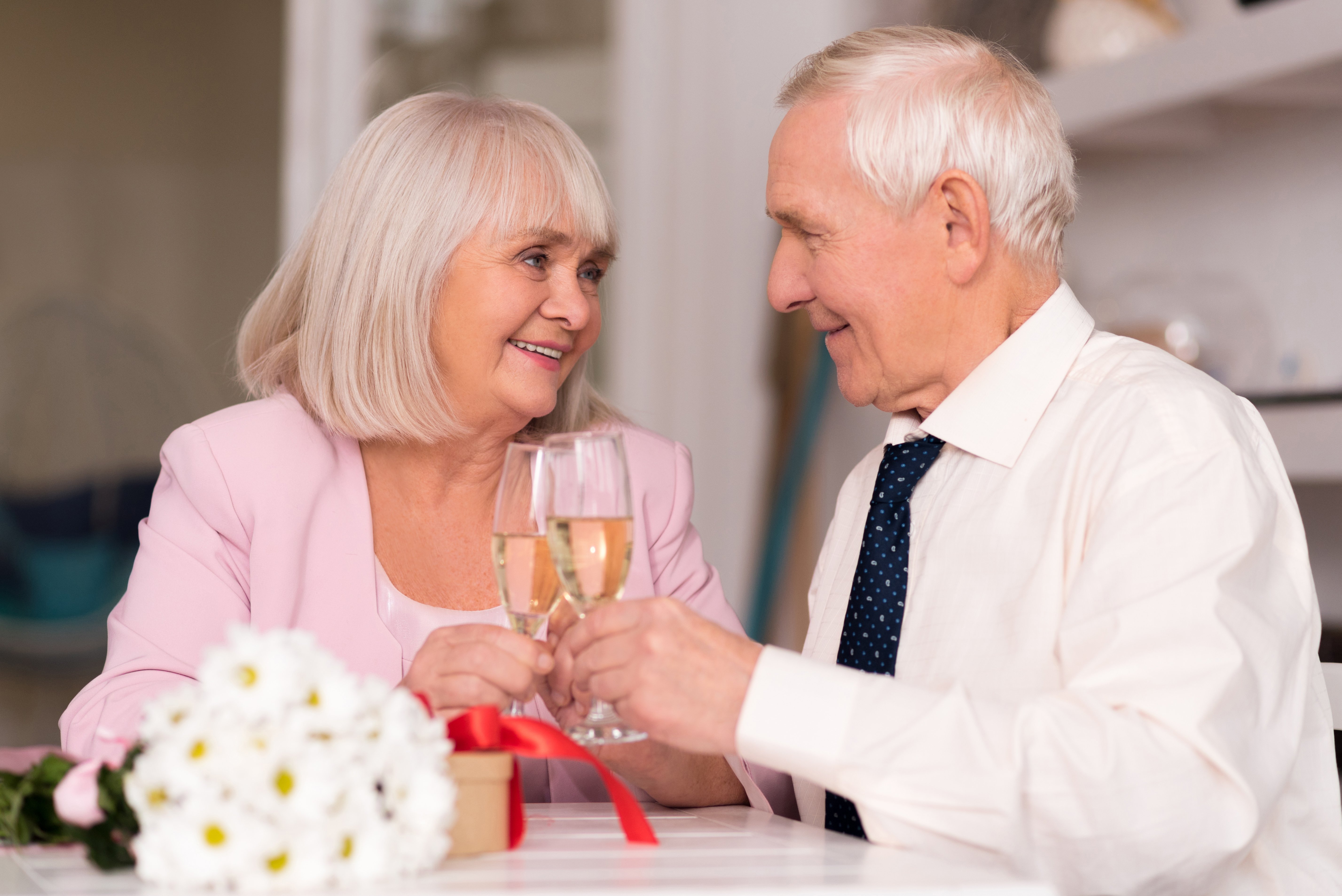 Cheerful senior couple raising their glasses to love | Photo: Shutterstock.com