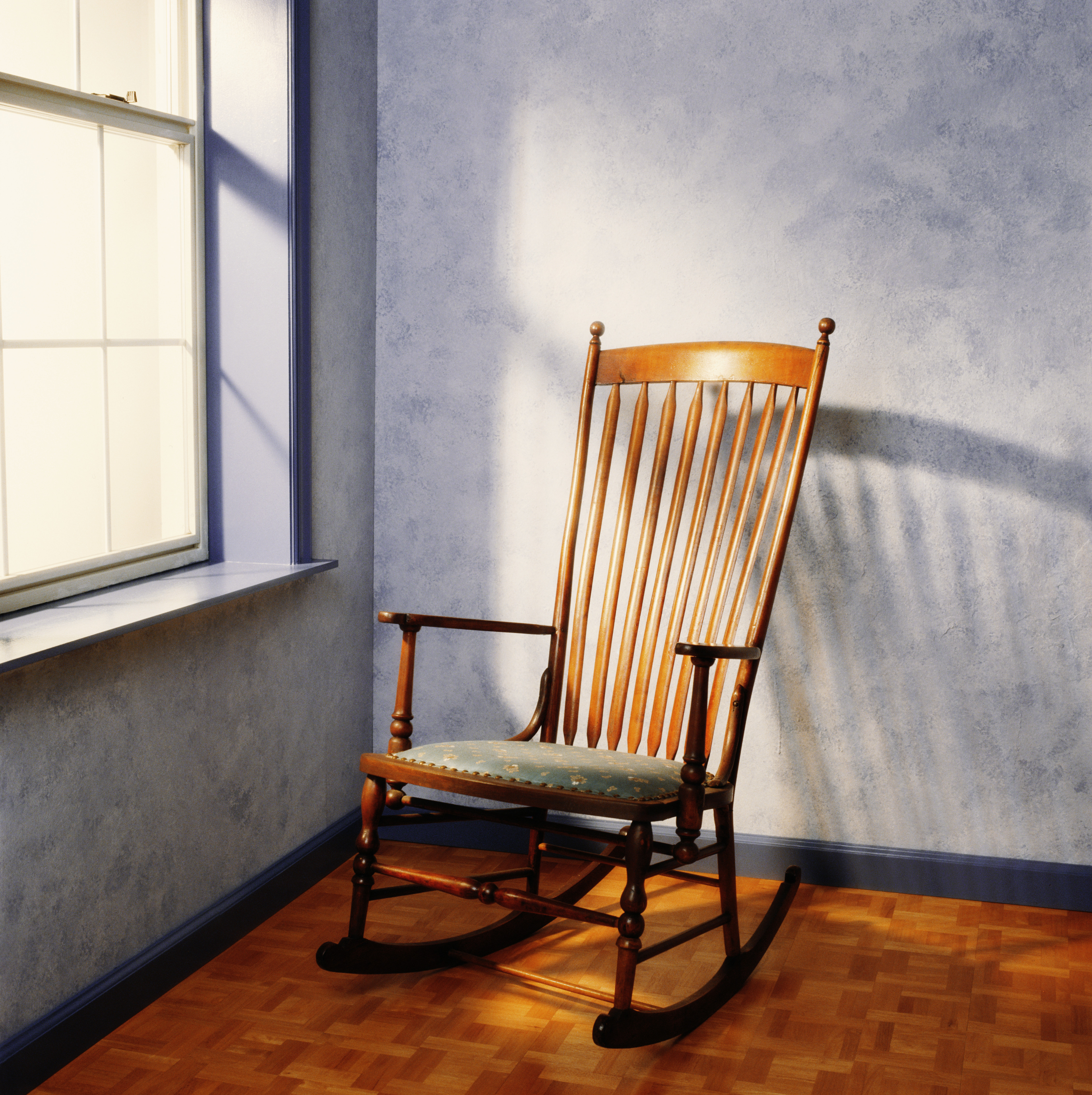 An empty rocking chair near a window | Source: Getty Images