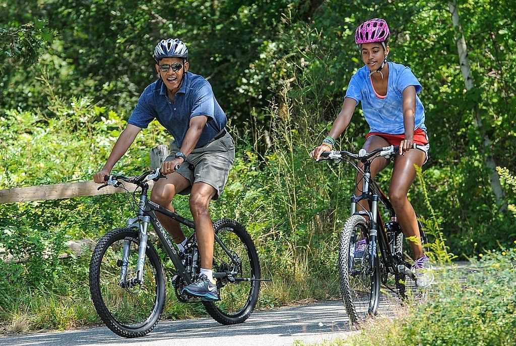 President Barack Obama (L) his daughter Malia Obama ride a bike during a vacation on Martha's Vineyard August 16, 2013. | Photo: GettyImages